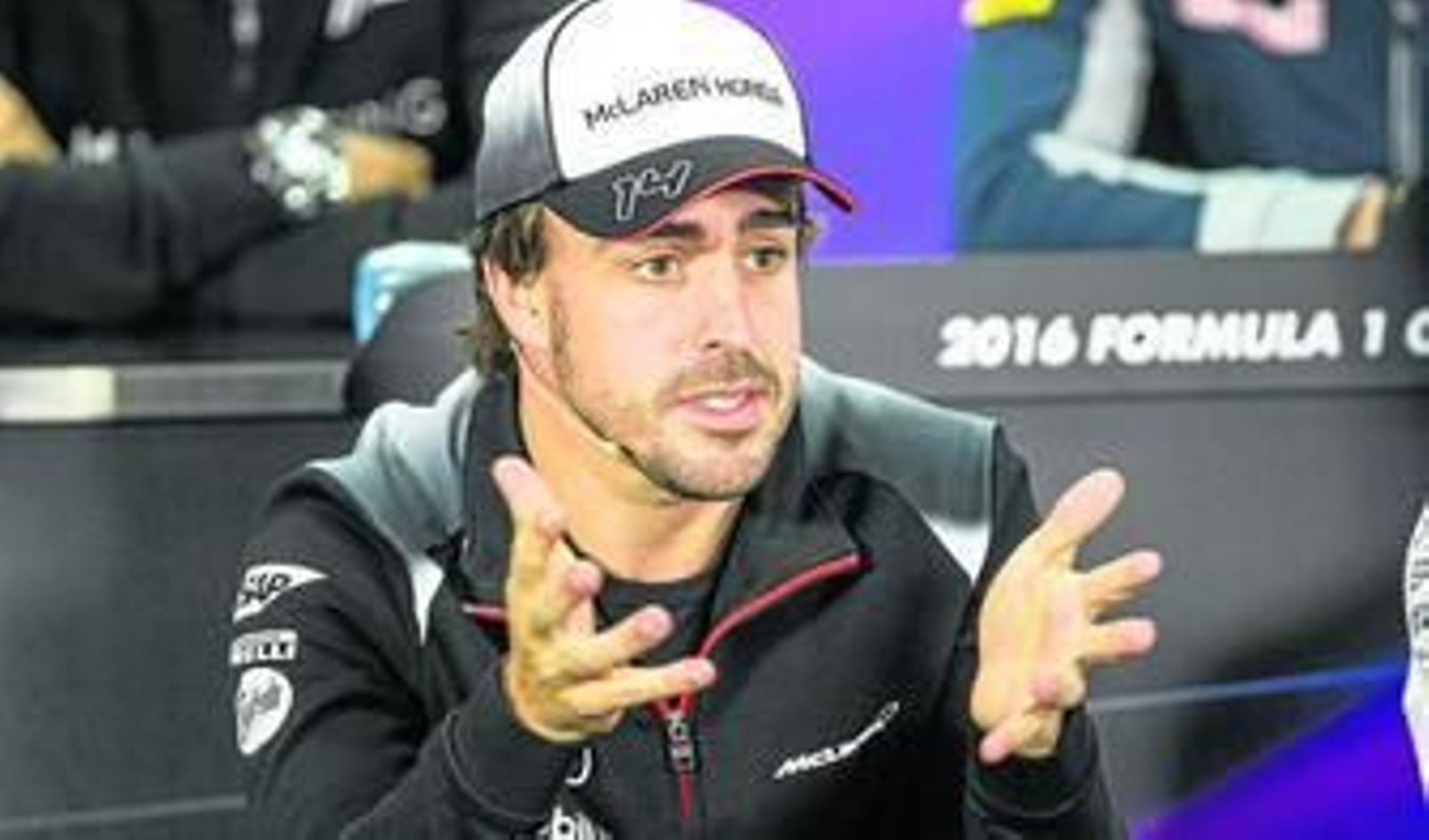Fernando Alonso da explicaciones en Bahréin con gesto visiblemente contrariado.