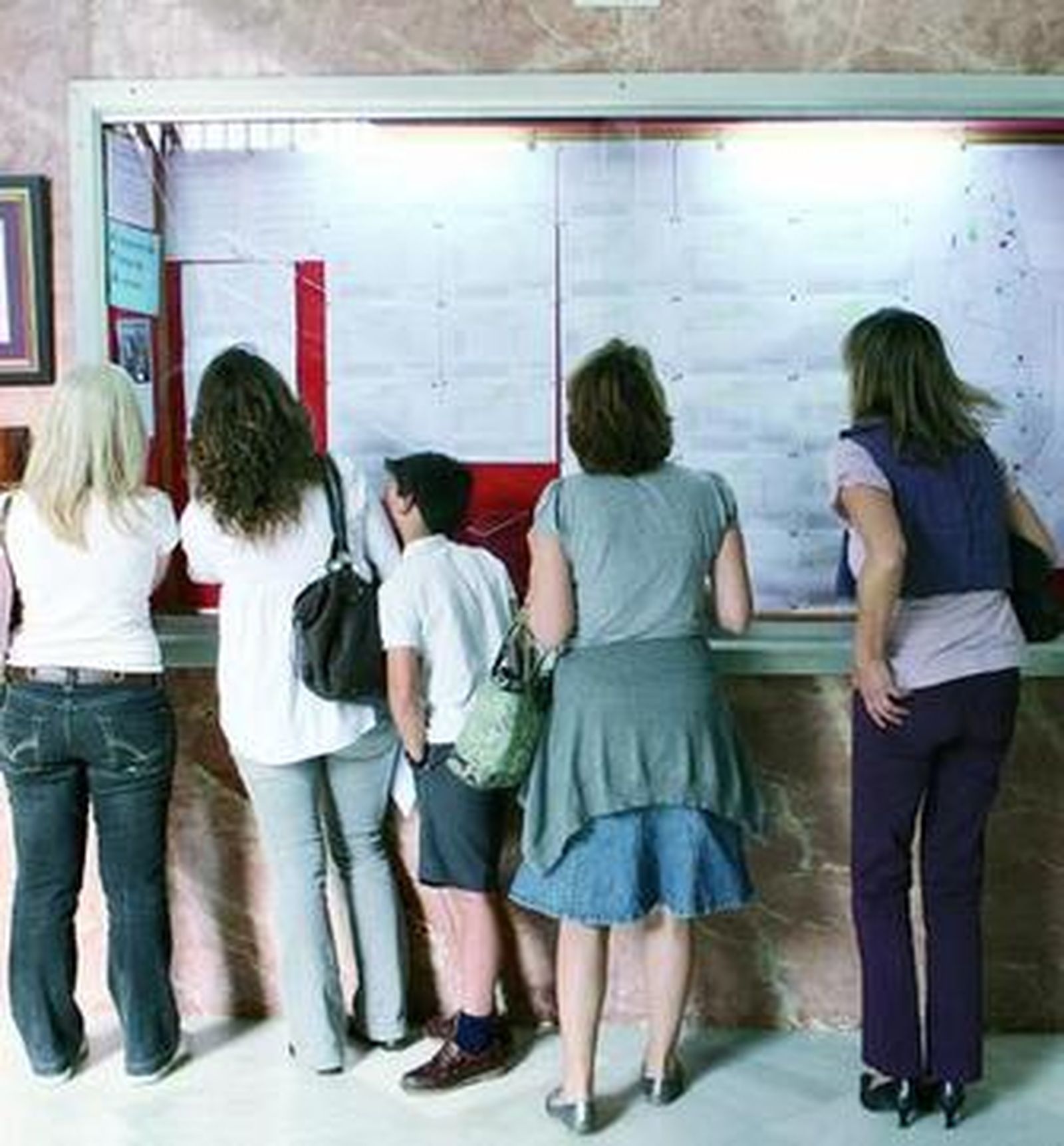 Varias madres comprueban si sus hijos están incluidos en la lista de alumnos admitidos del Claret.