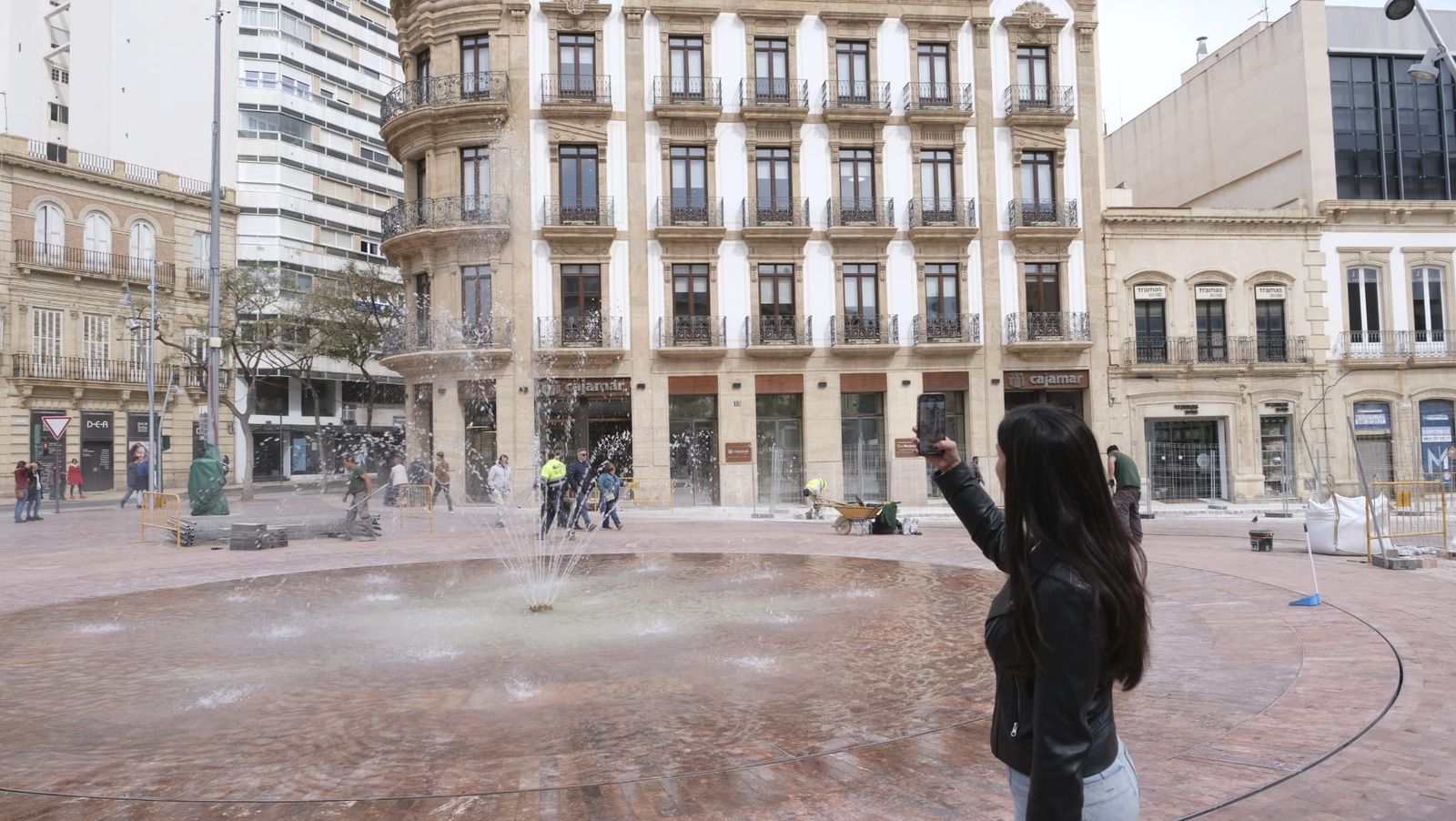 Una viandante graba la fuente d ela Puerta Purchena