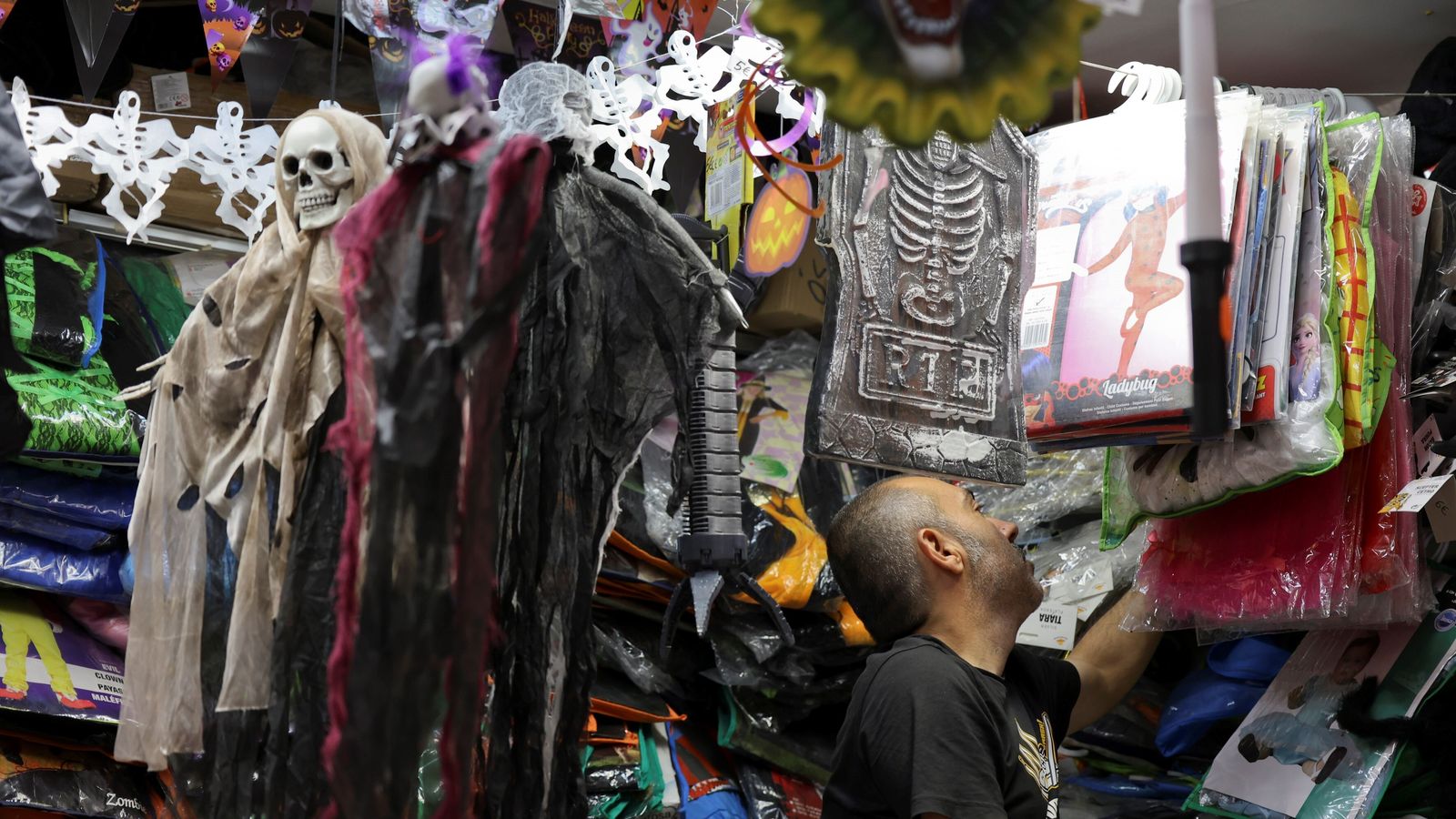 Uno de los trabajadores de la tienda buscando disfraces.