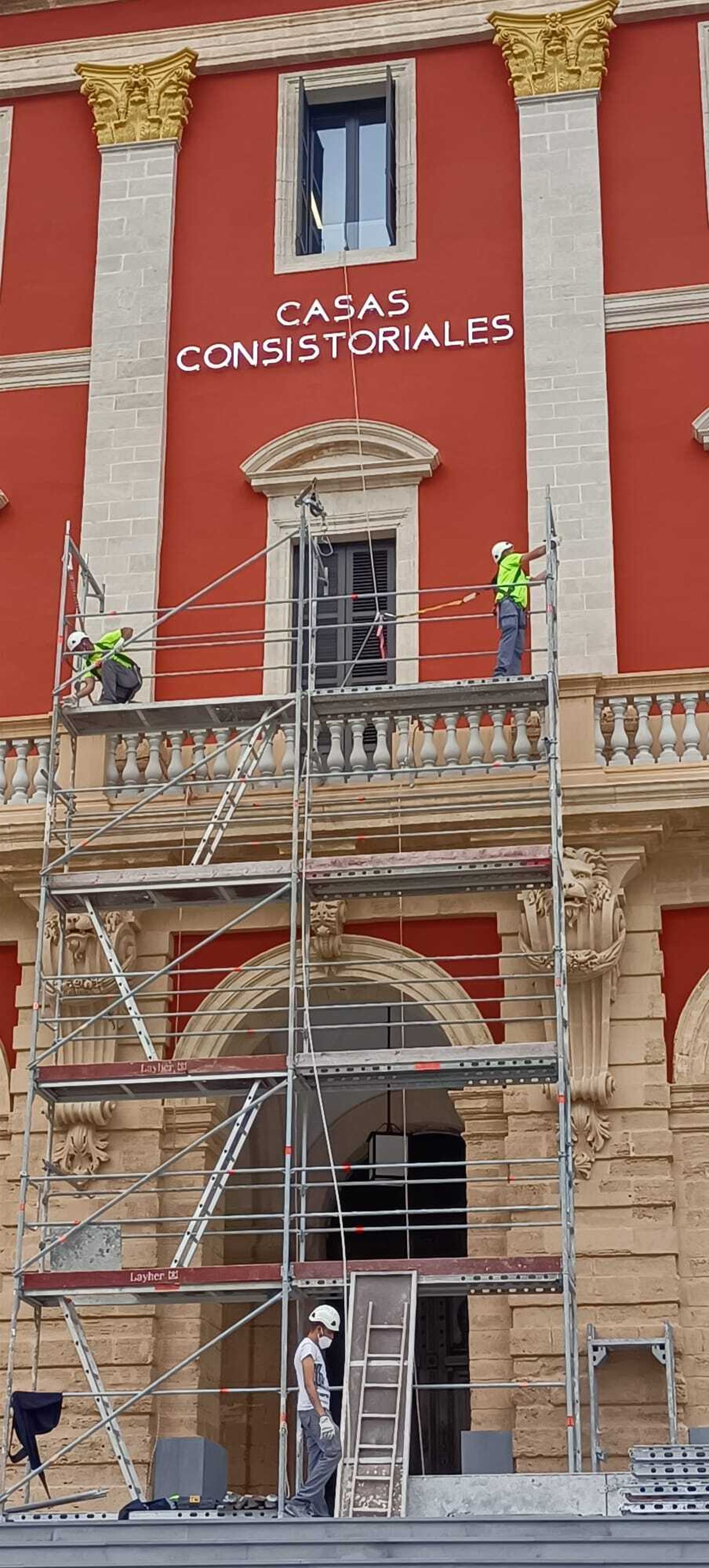 Trabajos para retirar el rótulo de la fachada del Ayuntamiento de San Fernando.