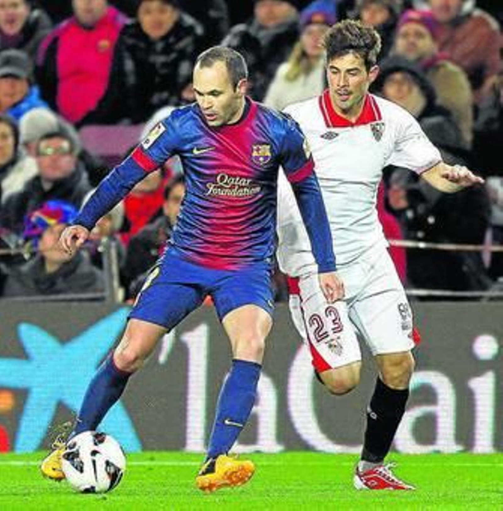 El sevillista Coke presiona al azulgrana Iniesta.