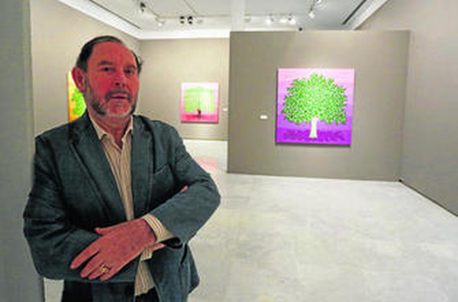 Evaristo Guerra posa en la sala de exposiciones del Rectorado junto a sus 'Árboles'.