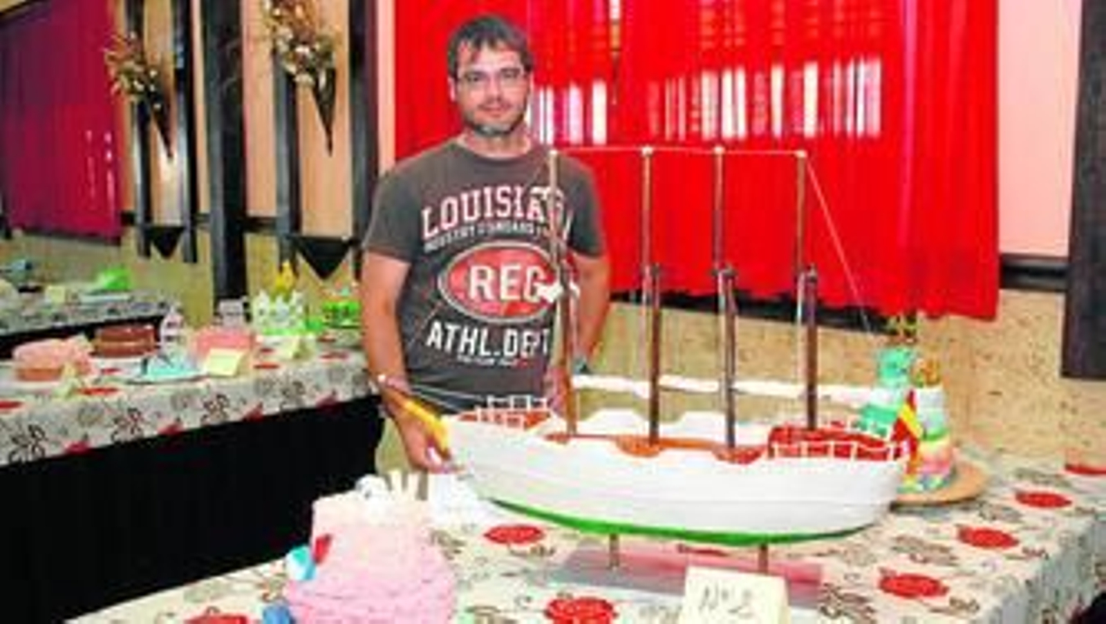 El ganador del primer premio profesional posa junto a su creación, que representa el Elcano.