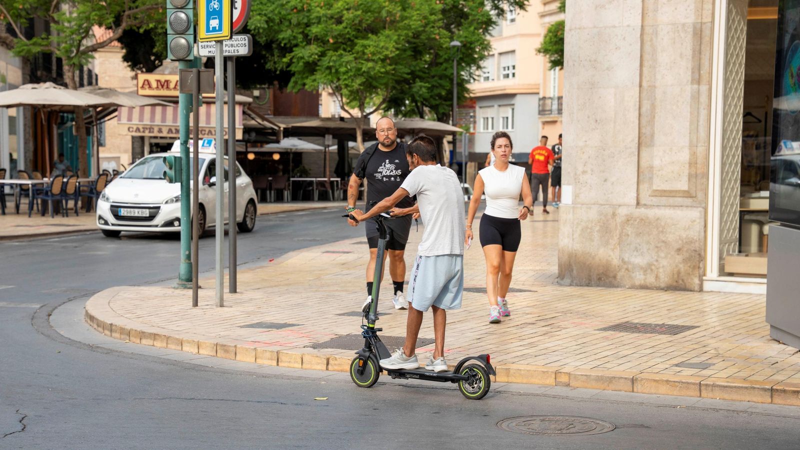 Un joven circula en patinete junto a una de las personas más conocidas de Almería, 'Langostino'