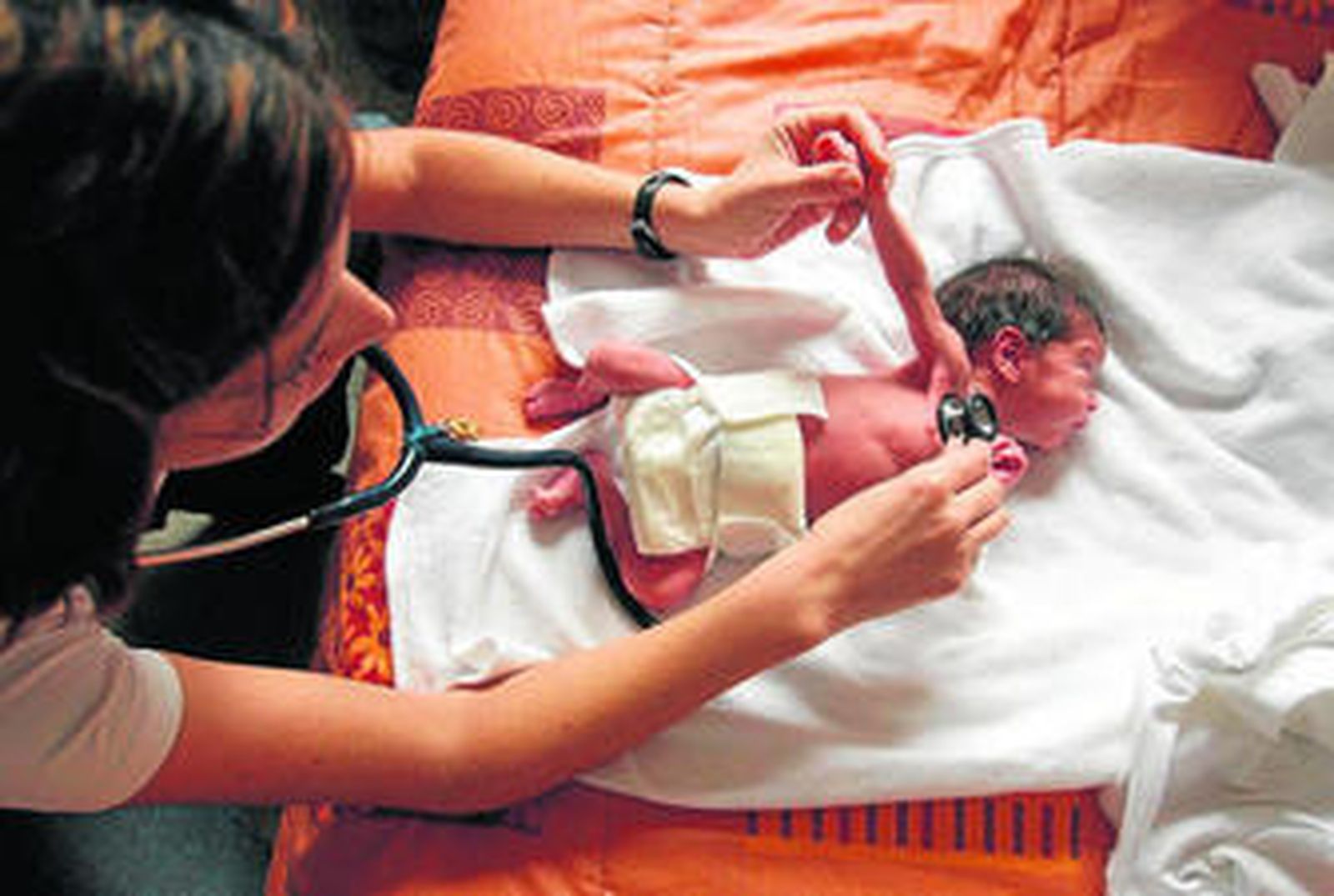 Una pediatra realiza una auscultación a un neonato.