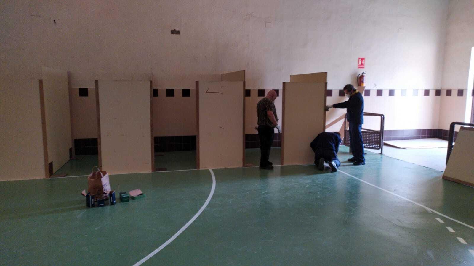 Operarios habilitando unas cabinas en el interior del pabellón Antonio Vega 'Veguita'.