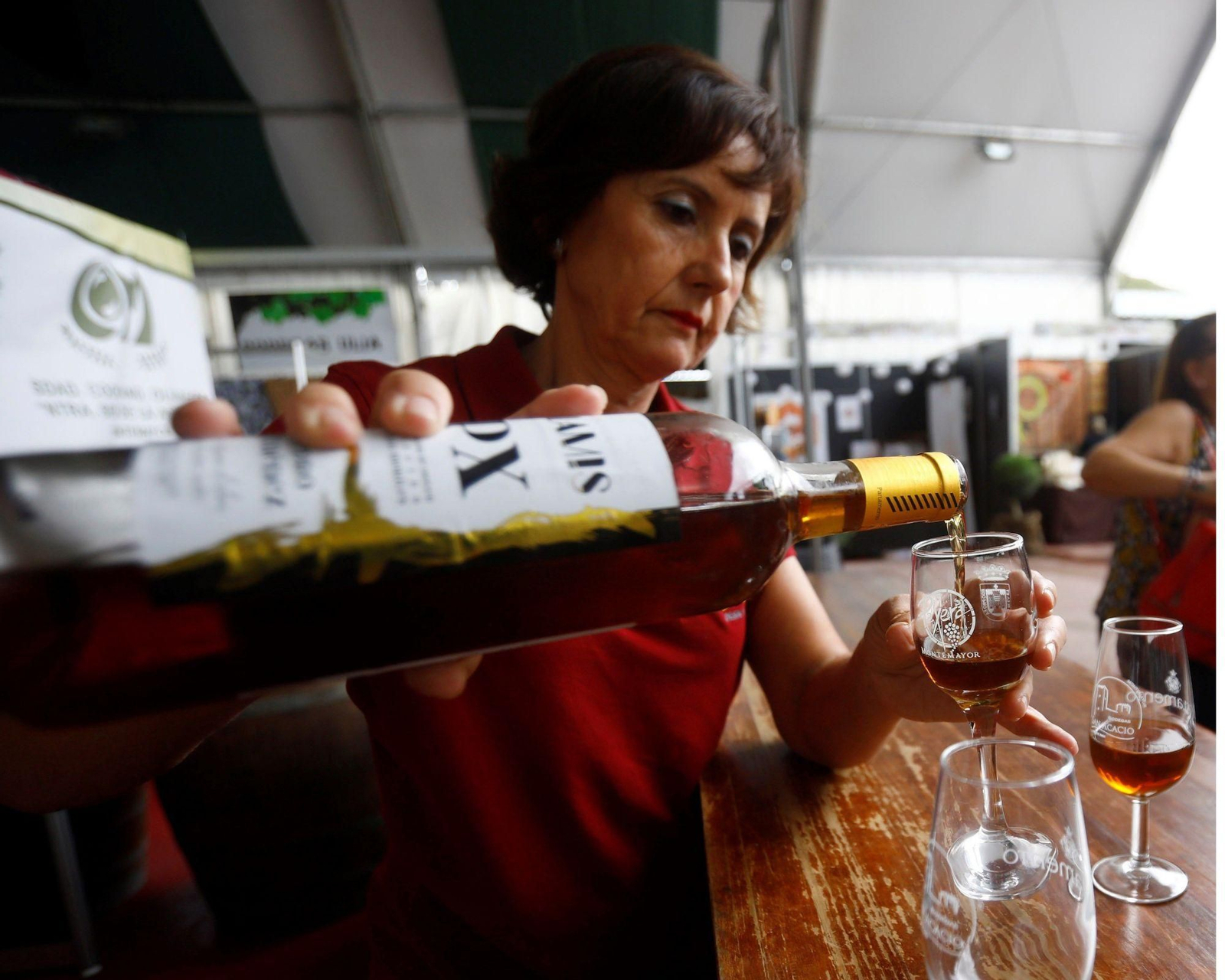 Mujer sirviendo una copa de vino dulce