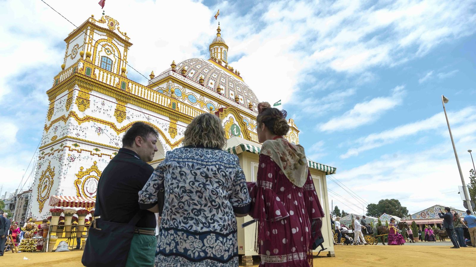 Guía turística y turistas junto a la portada de la Feria