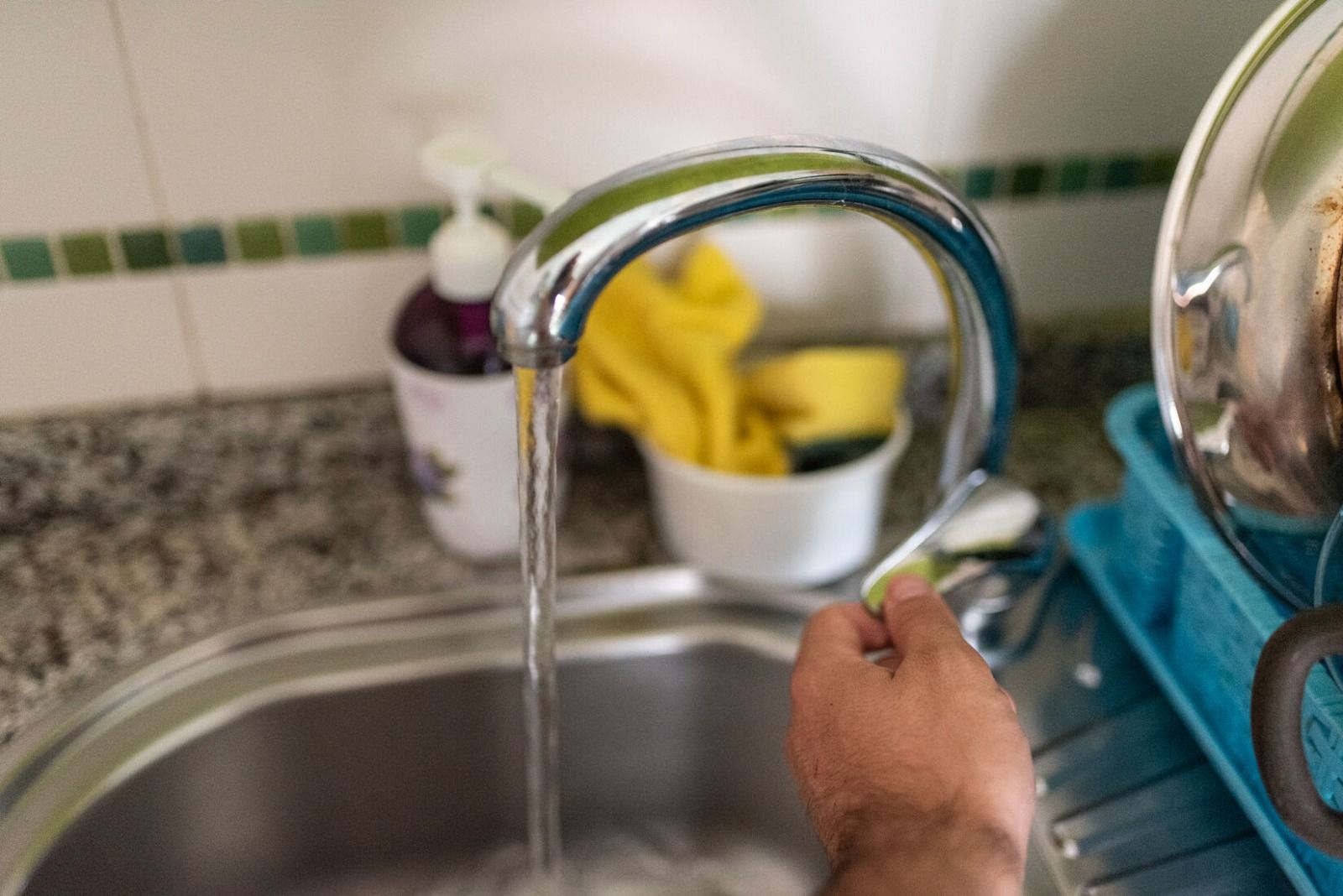 Un grifo abierto en el fregadero de una cocina.