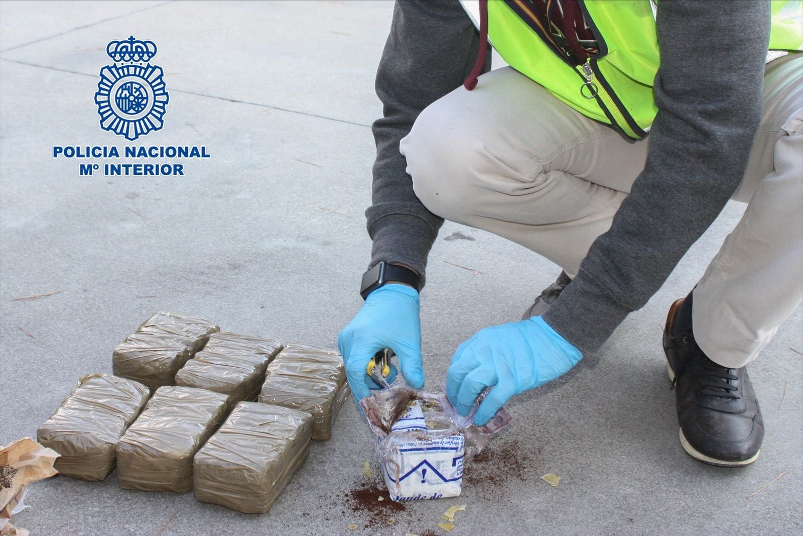 Un agente abre paquetes de droga.