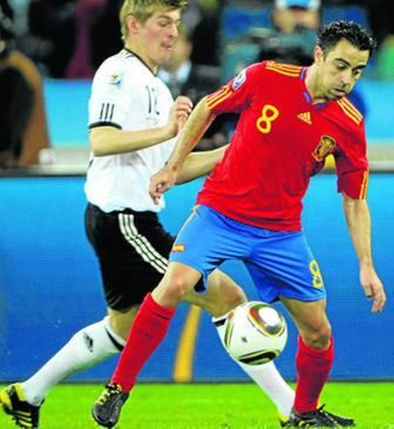 Xavi protege el balón ante la presión del alemán Kroos.