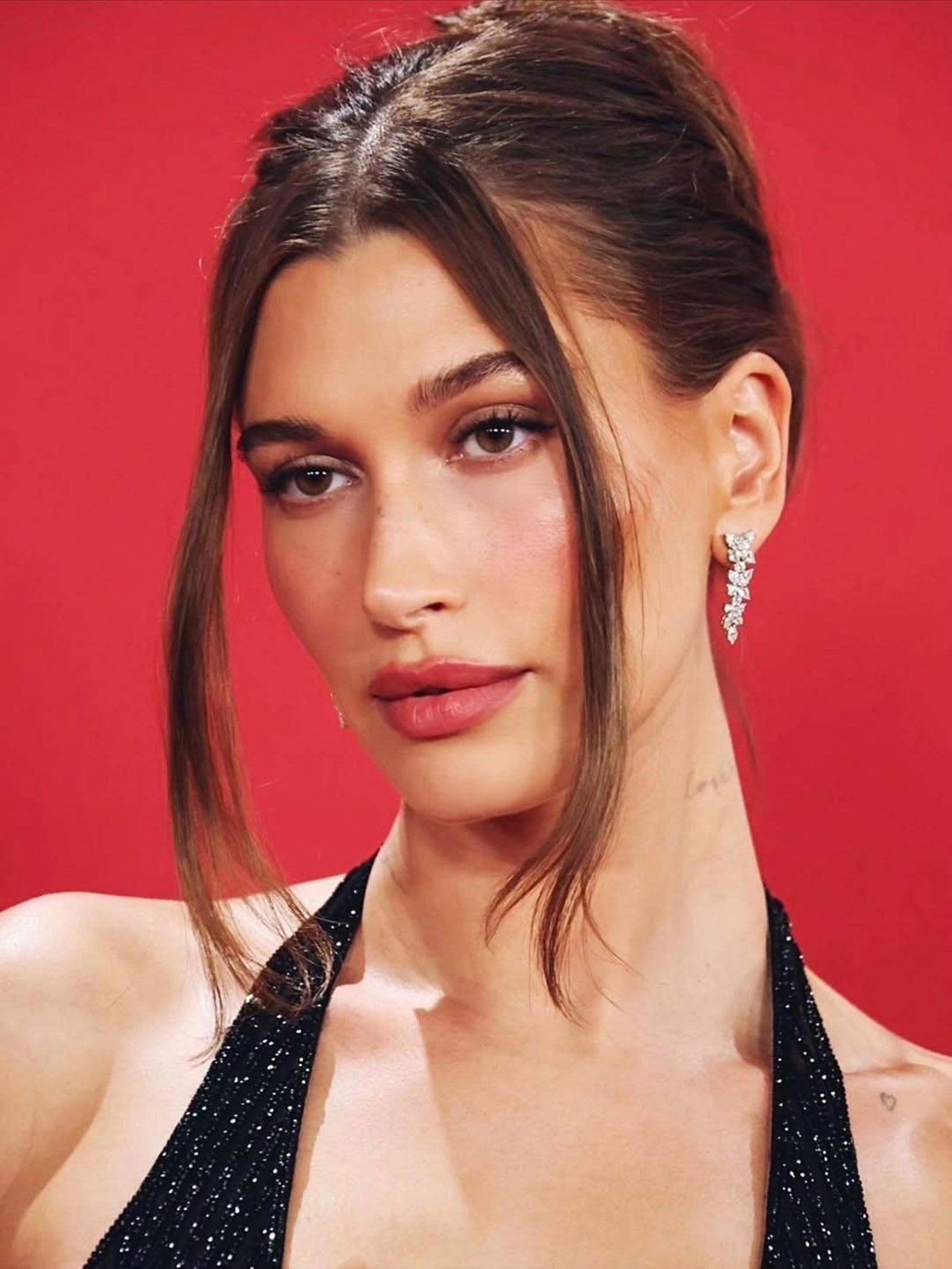 Hailey Bieber es una de las celebs que siempre apuestan por un recogido bajo con un par de mechones sueltos enmarcando el rostro.