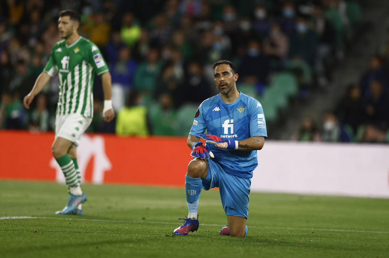 Claudio Bravo, con gesto serio ante Guido, al fondo.