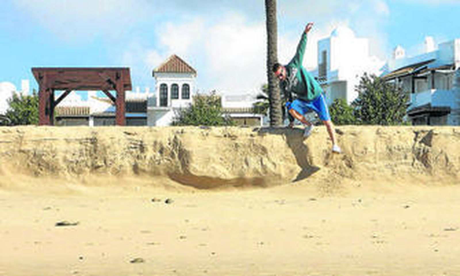 Una pareja pasea frente a un enorme escalón frente a la urbanización Pinomar.