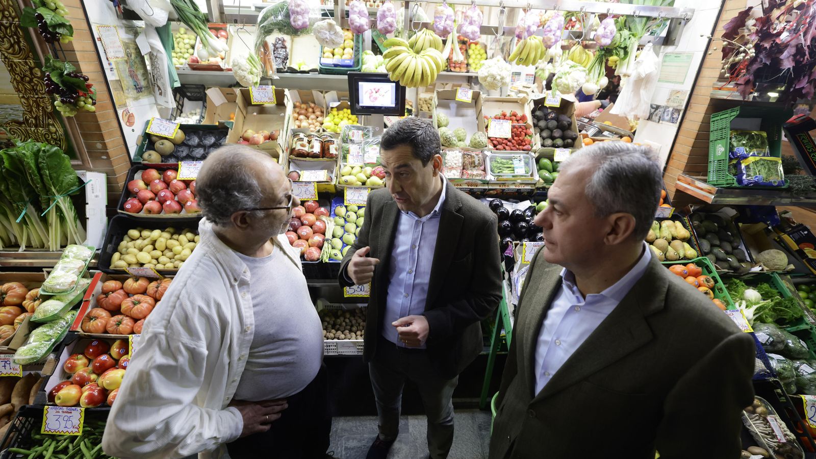 Moreno y Sanz hablan con un frutero en el mercado de Triana.
