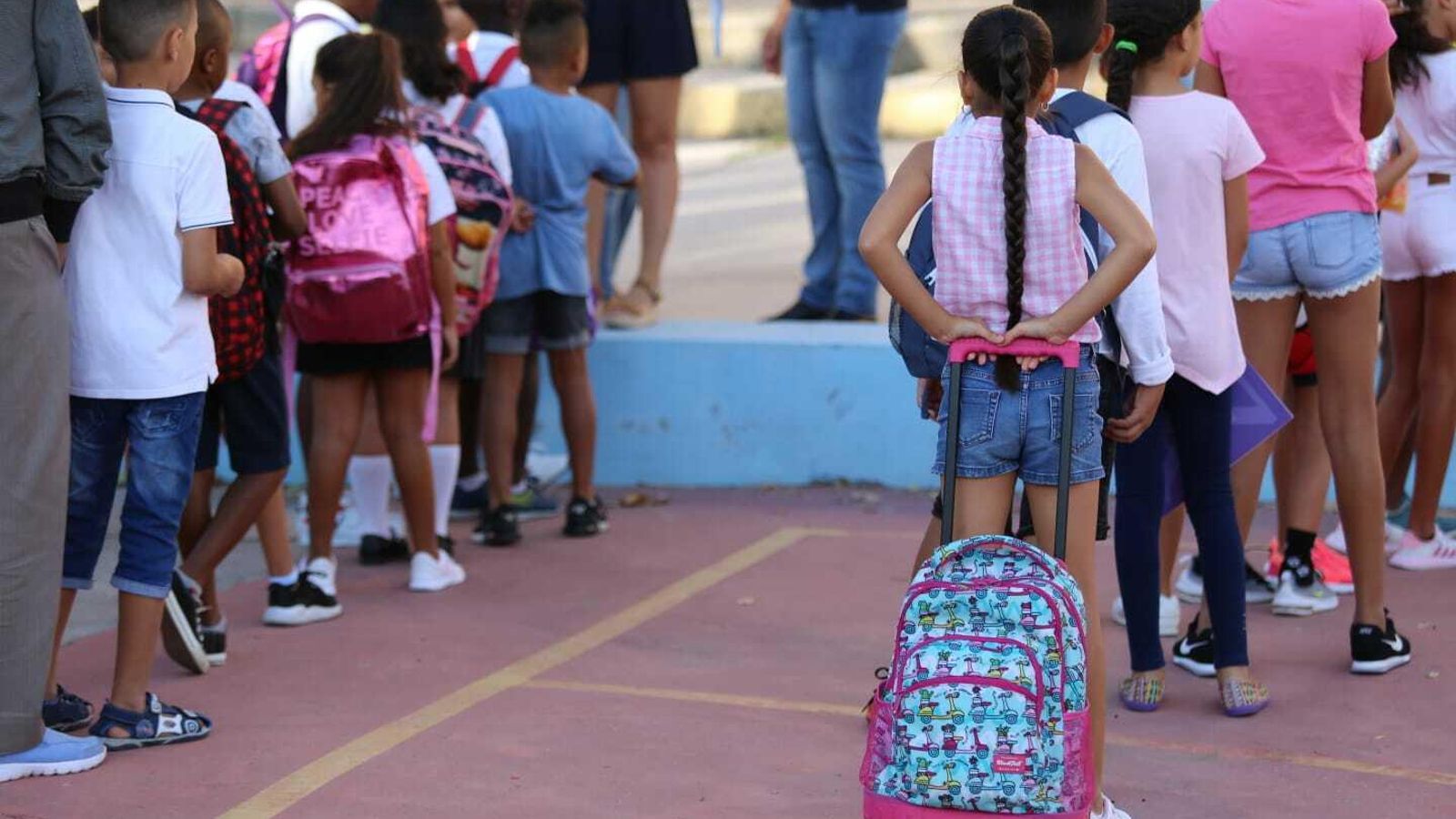 Alumnos en fila preparados para entrar en clase.