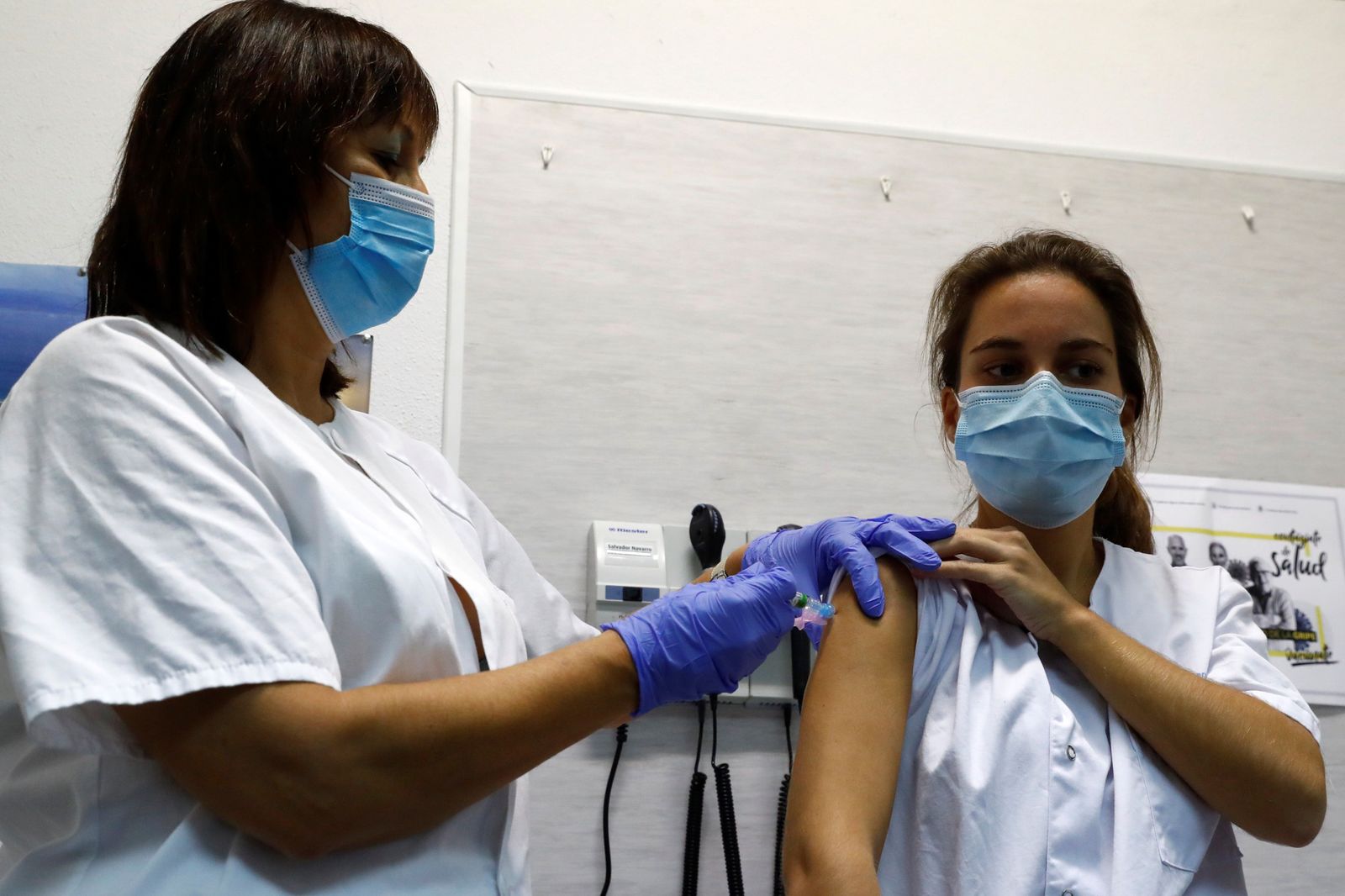 Una sanitaria recibe una vacuna en un centro sanitario.