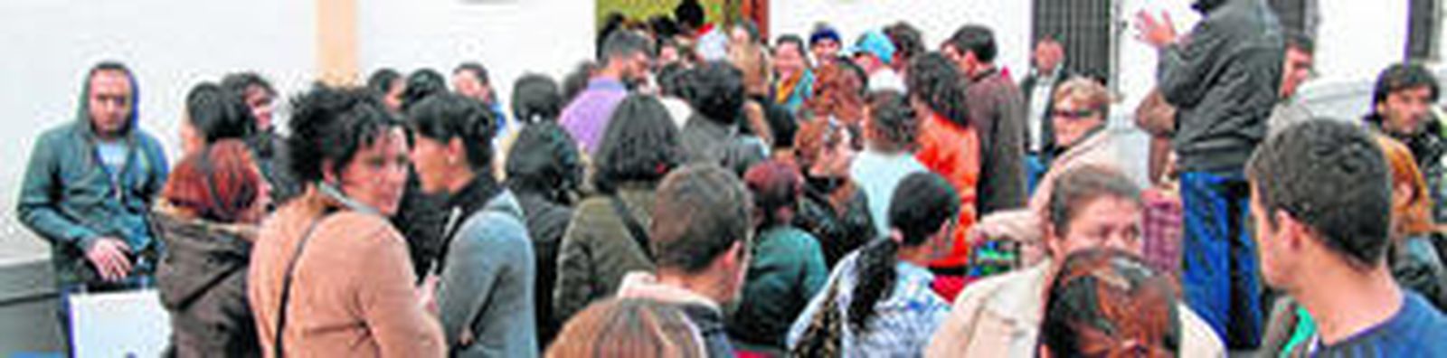 Grupo de personas que aguardan para ser atendidas en una de las sedes de Cáritas.