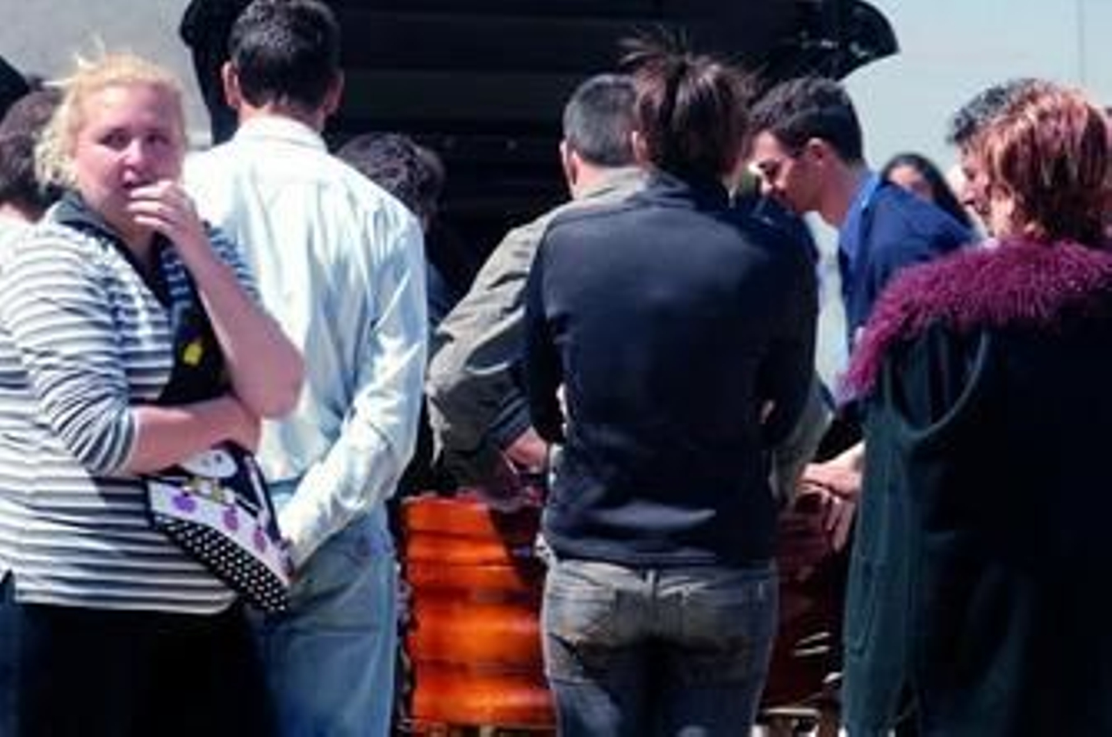 1. Familiares y amigos de los dos fallecidos flanquean el camino que conduce hasta el Instituto de Medicina Legal, a cuyo exterior llegaron el jueves por la tarde. 2. El féretro de uno de los jóvenes es introducido en un coche fúnebre. 3. Momento en el que unos familiares entran en el edificio para identificar los cadáveres.