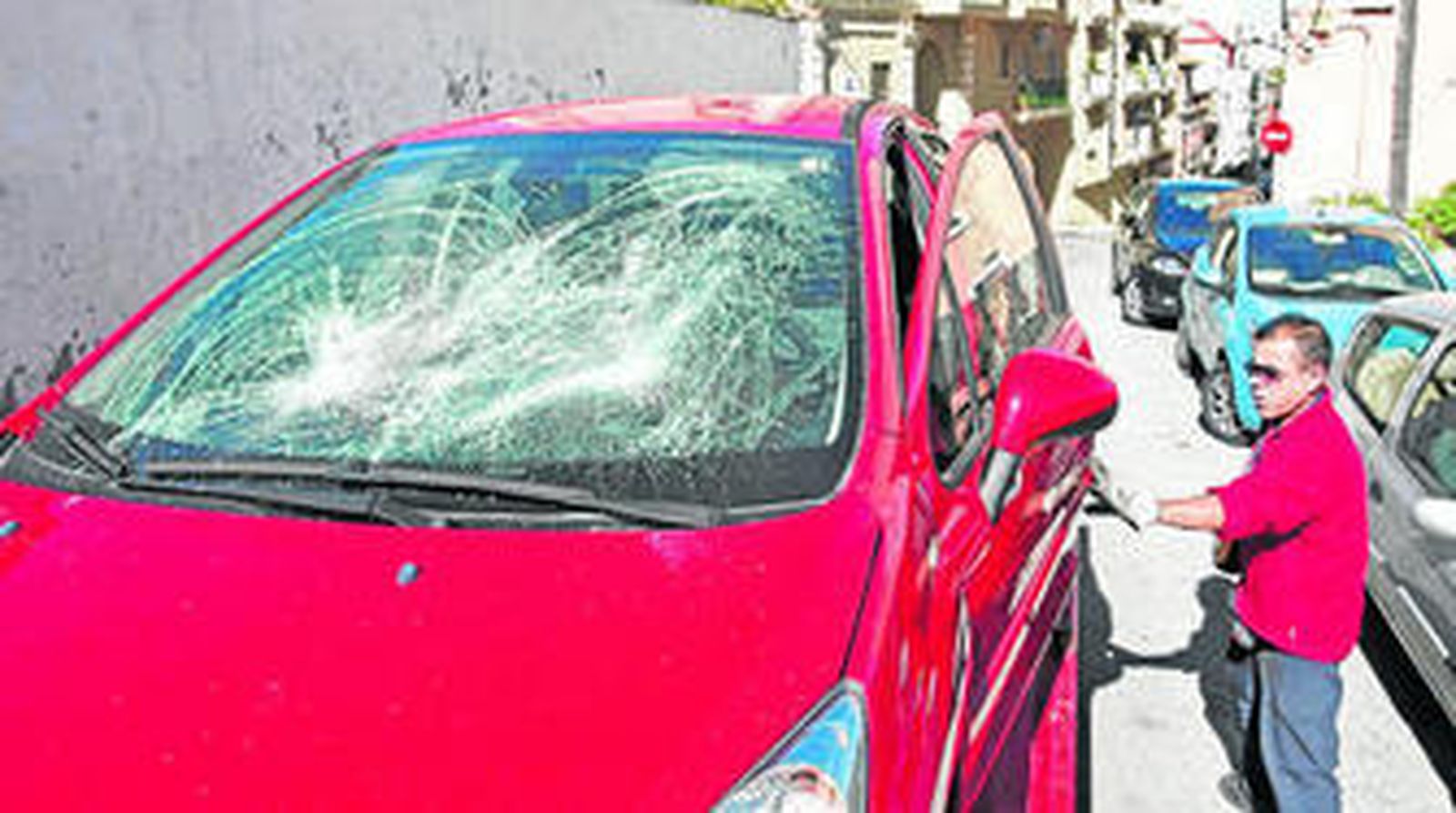 Un trabajador retira uno de los vehículos dañados, ayer al mediodía.