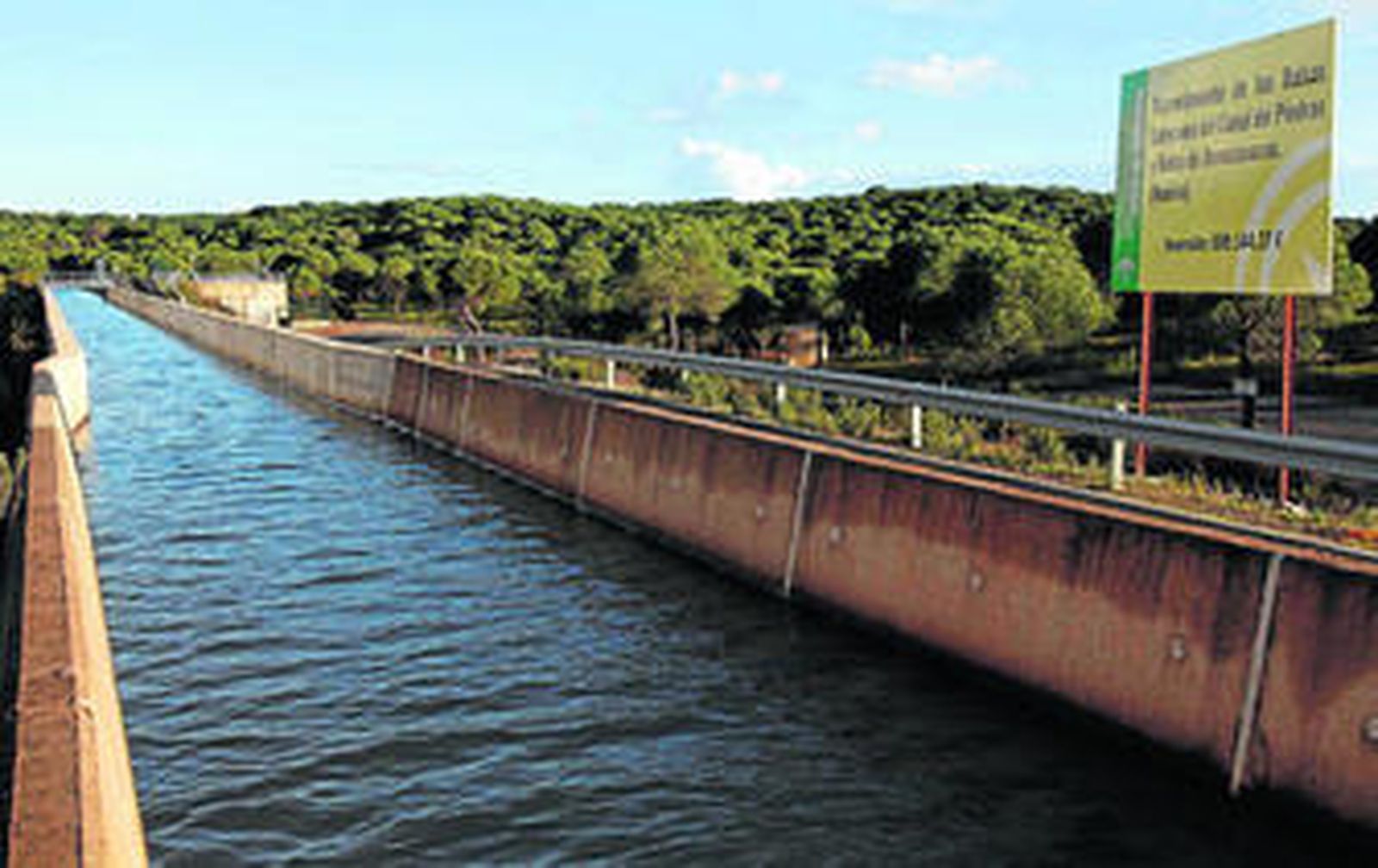Un cartel junto al canal anuncia el proyecto y la inversión prevista.