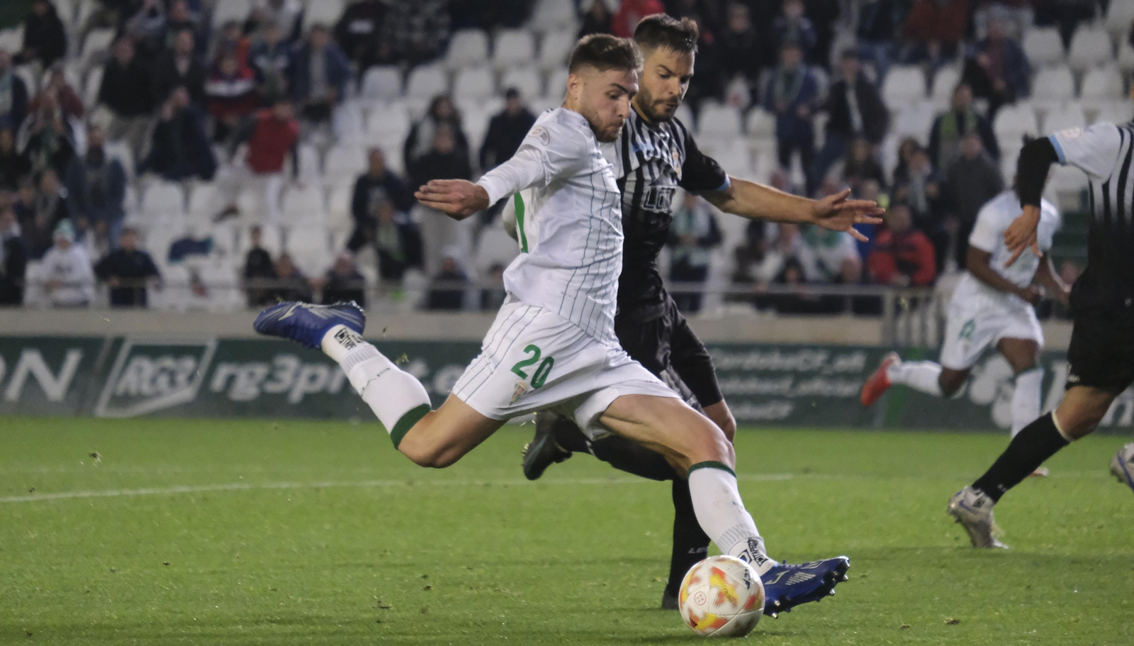 Antonio Casas golpea al balón ante la presión de un rival.