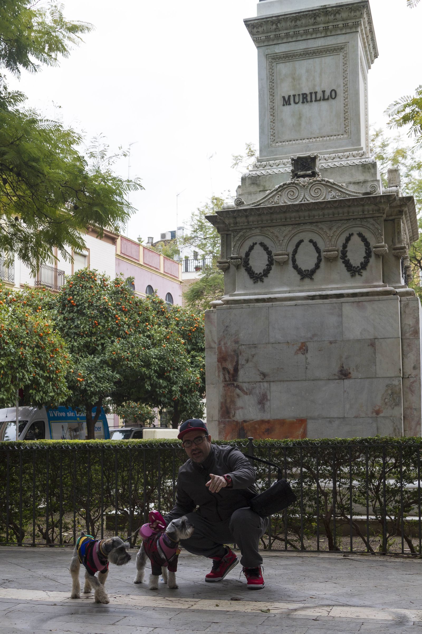 Phanor Díaz, con sus dos perros schnauzer miniatura, junto a la estatua de Murillo en la plaza del Museo.