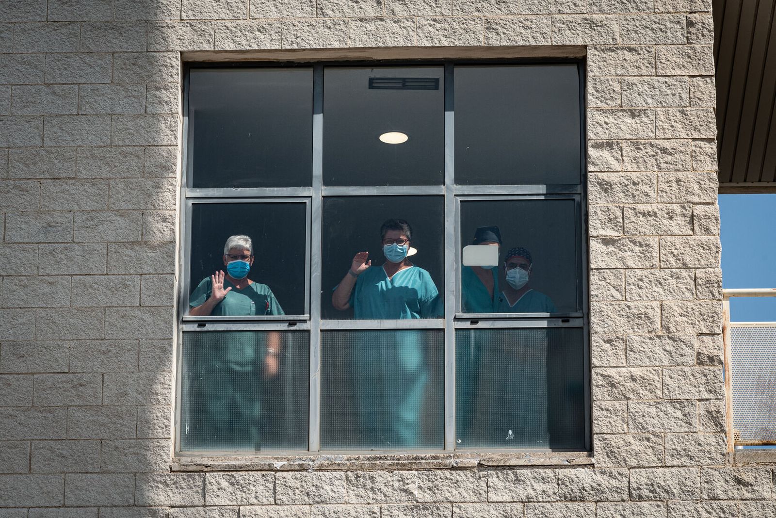 Un grupo de sanitarios observa desde la ventana del Hospital Juan Ramón Jiménez.