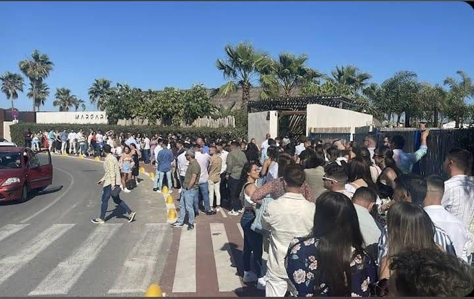Jóvenes haciendo cola para entrar en los chiringuitos de Puerto Sherry.