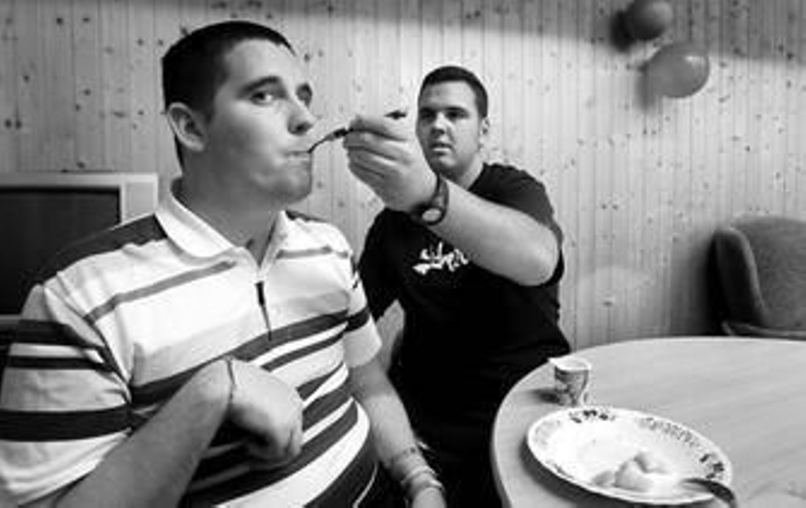 Un cuidador de la asociación gaditana de personas con daño cerebral ayuda a Juan Antonio a comer.