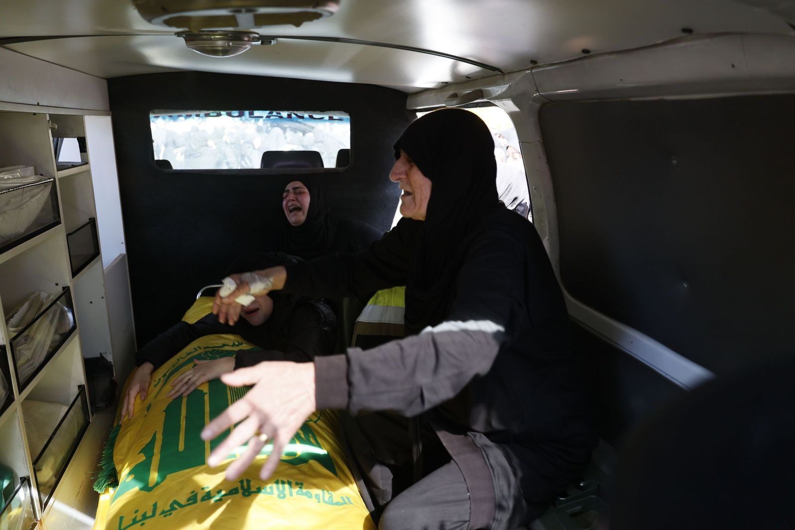 Dos mujeres lloran ante un féretro cubierto con la bandera de Hezbolá en Baalbek, en el Líbano.