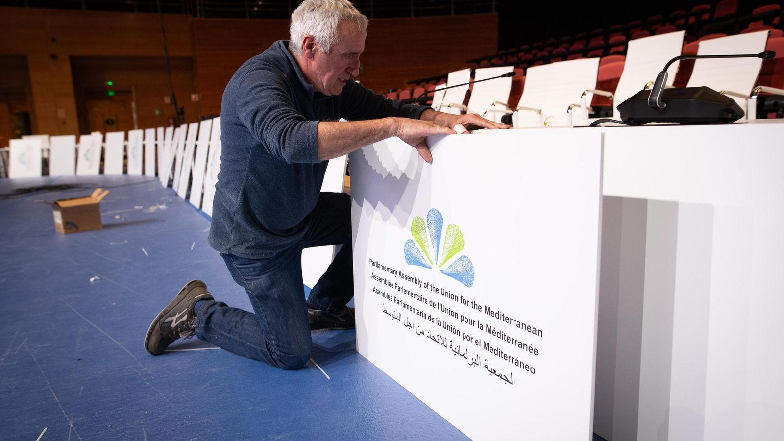 Un operario se afana en los últimos trabajos preparativos de la reunión