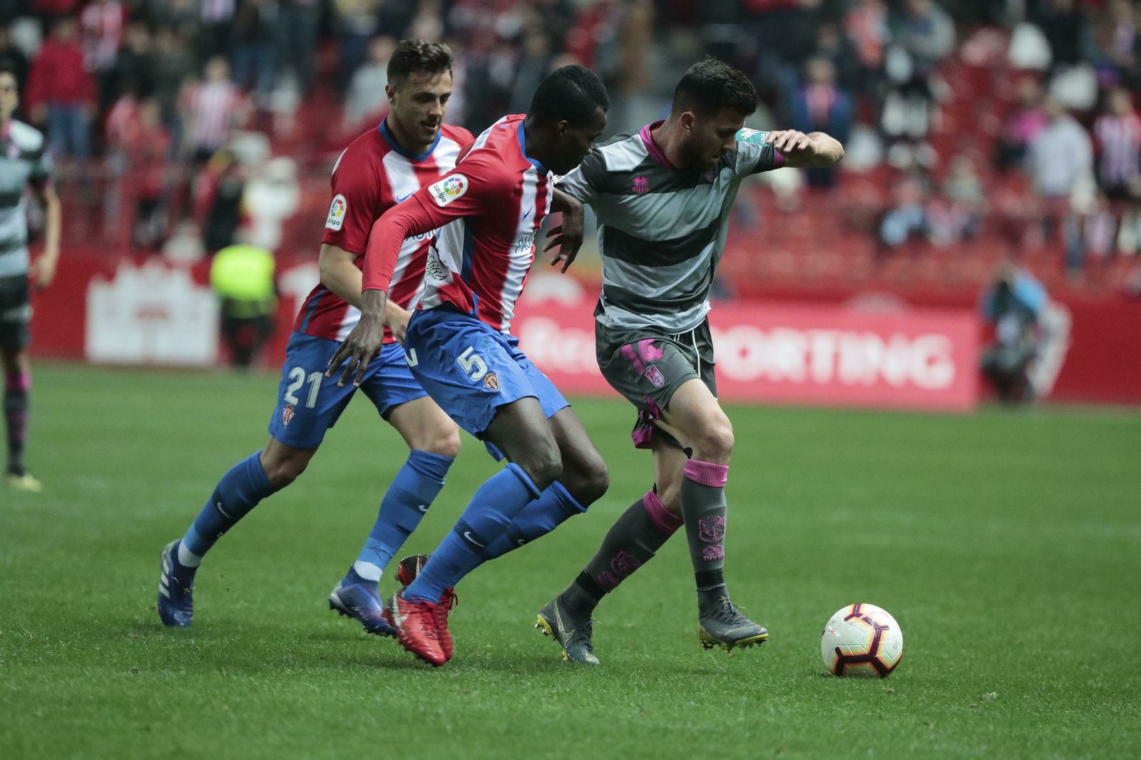 Fede Vico ante dos rivales en el partido contra el Sporting