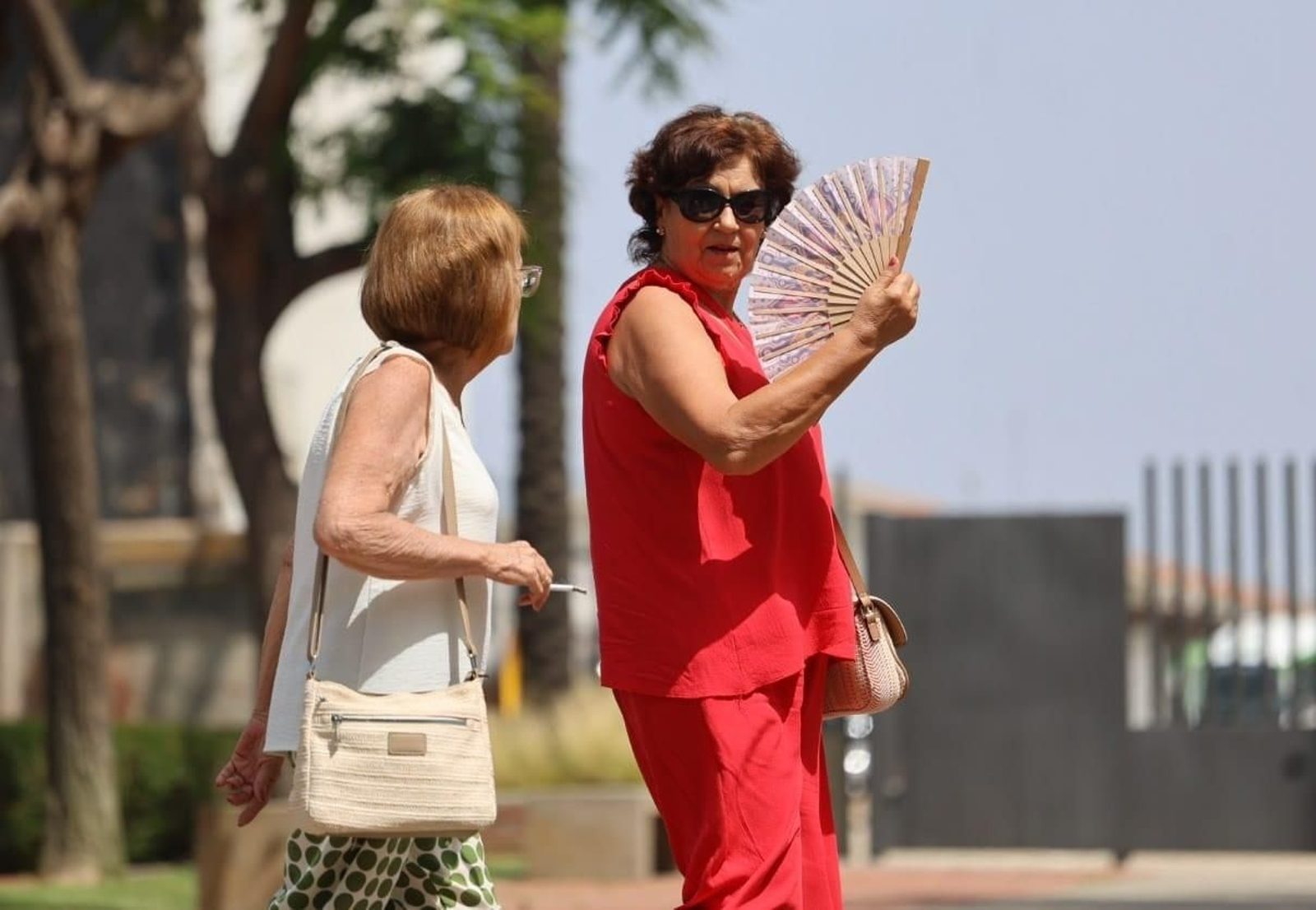 Una señora se abanica para tratar de paliar el calor.