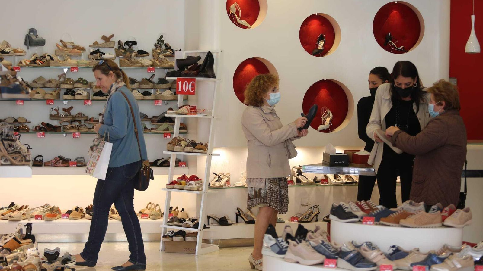 Personas con y sin mascarilla en el interior de una tienda.