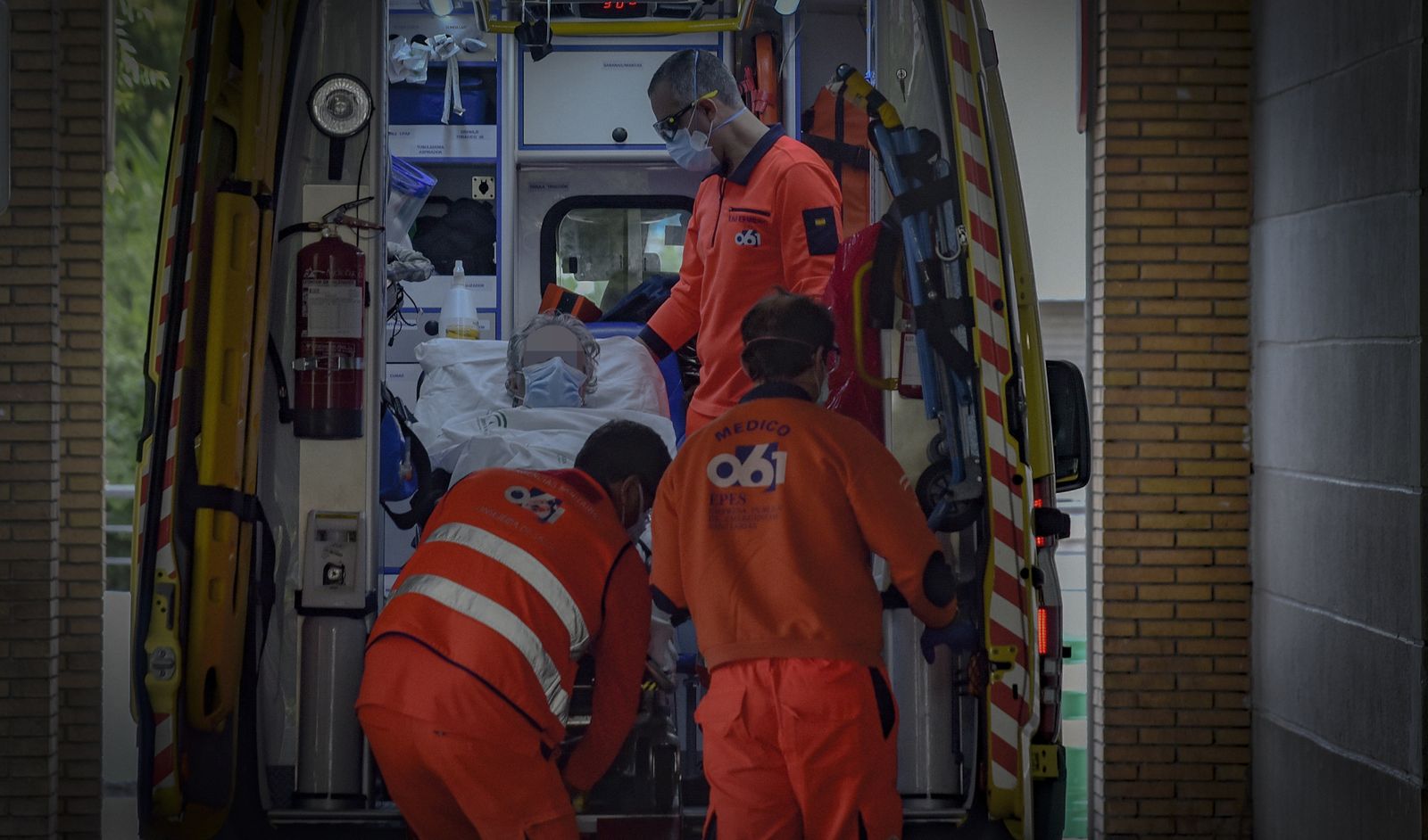 Sanitarios del 061 trasladan a una mujer en ambulancia a las Urgencias del Hospital Virgen Macarena.