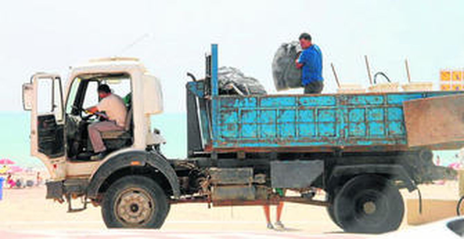 Operarios recogen bolsas de basura, ayer, en el paseo marítimo de Barbate.