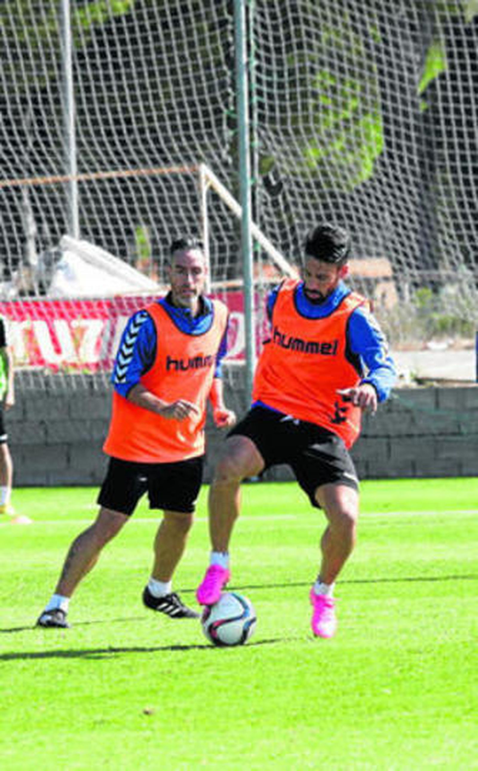 Kike Márquez controla el balón en un entrenamiento ante la atenta mirada de Abel Gómez.