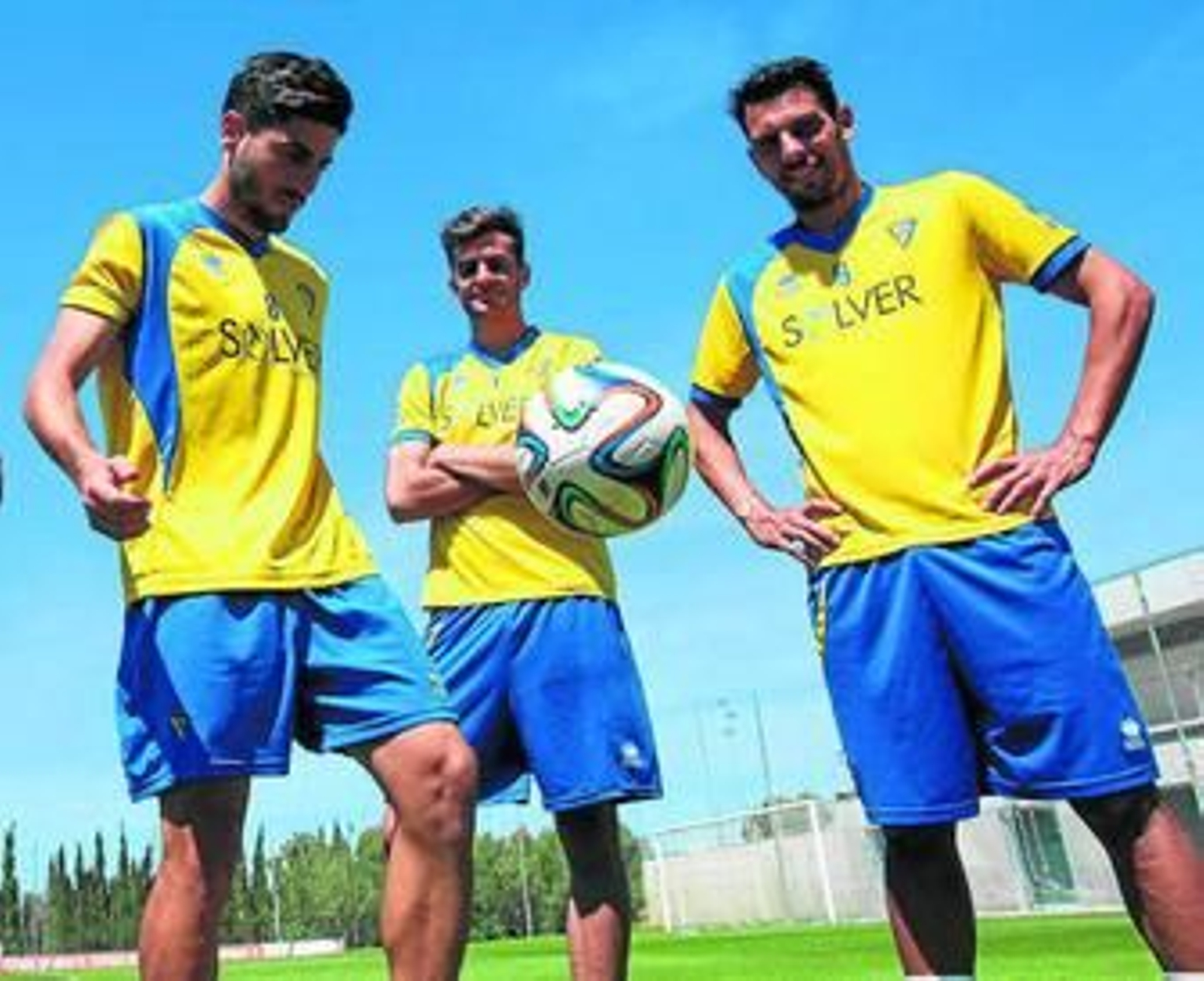 El centrocampista Juanma Espinosa juguetea con un balón en presencia de Mantecón (d) y Juan Villar.