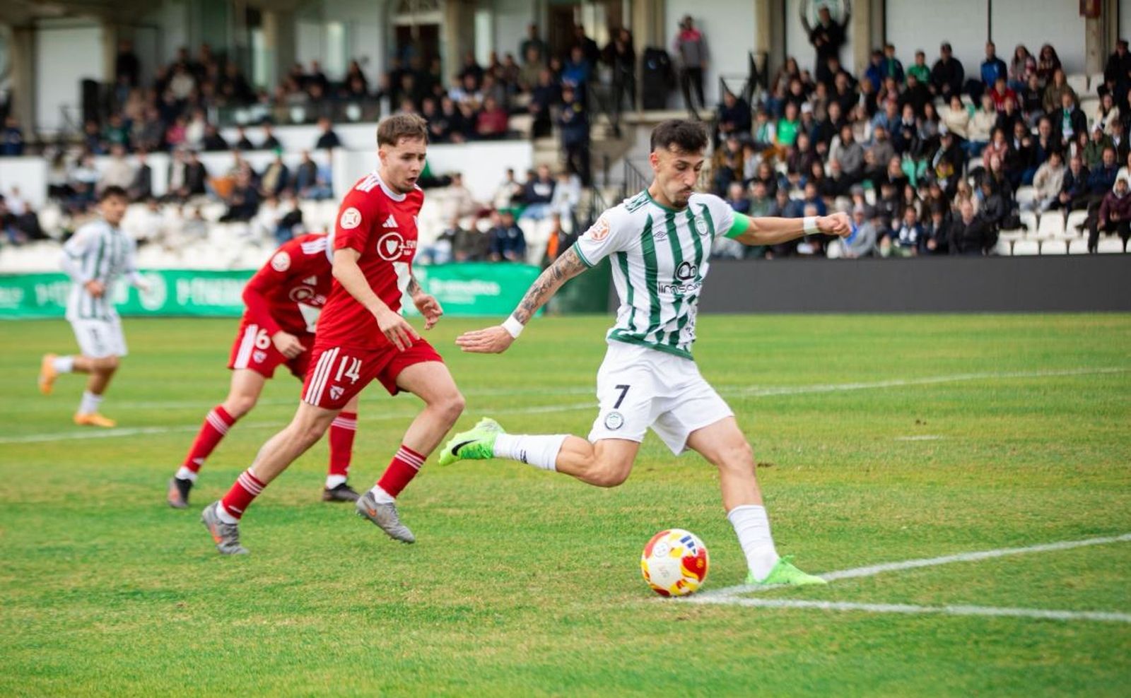 Un jugador local remata a portería en presencia de un sevillista.