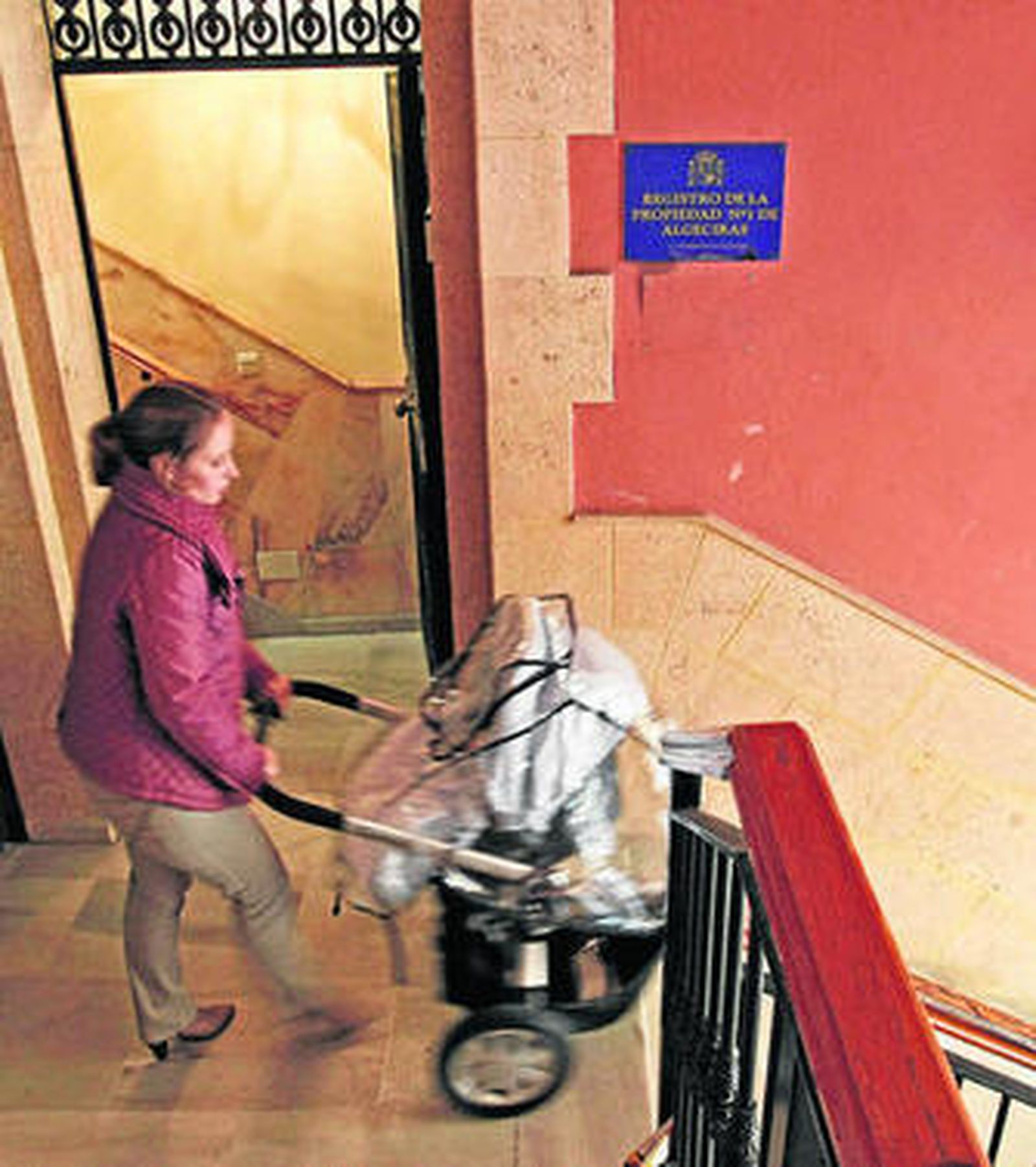 Una mujer con un carro de bebé, ayer, en el Registro de la Propiedad.