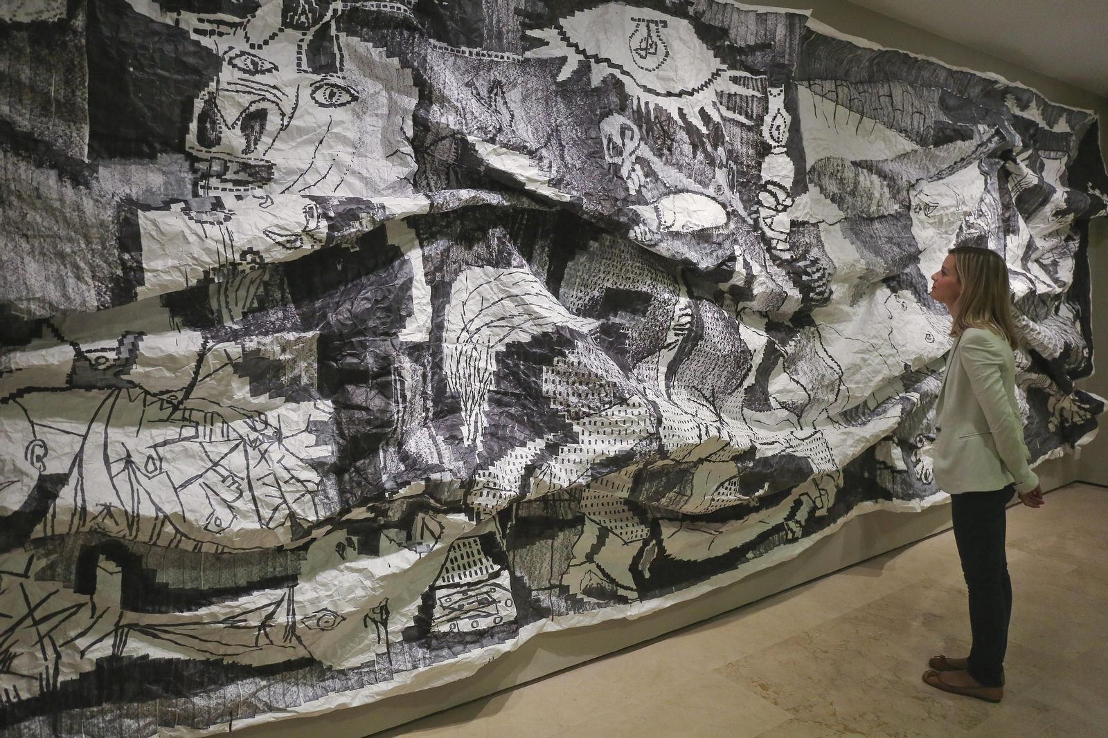 Una mujer contempla la obra 'Guernica XL, serie extrujados' del cántabro Javier Arce. Una mujer contempla la obra 'Guernica XL, serie extrujados' del cántabro Javier Arce.