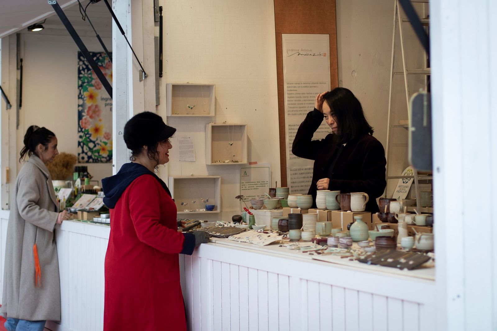 Varias personas conversan con los dueños de los puestos instalados en Fuente de las Batallas.