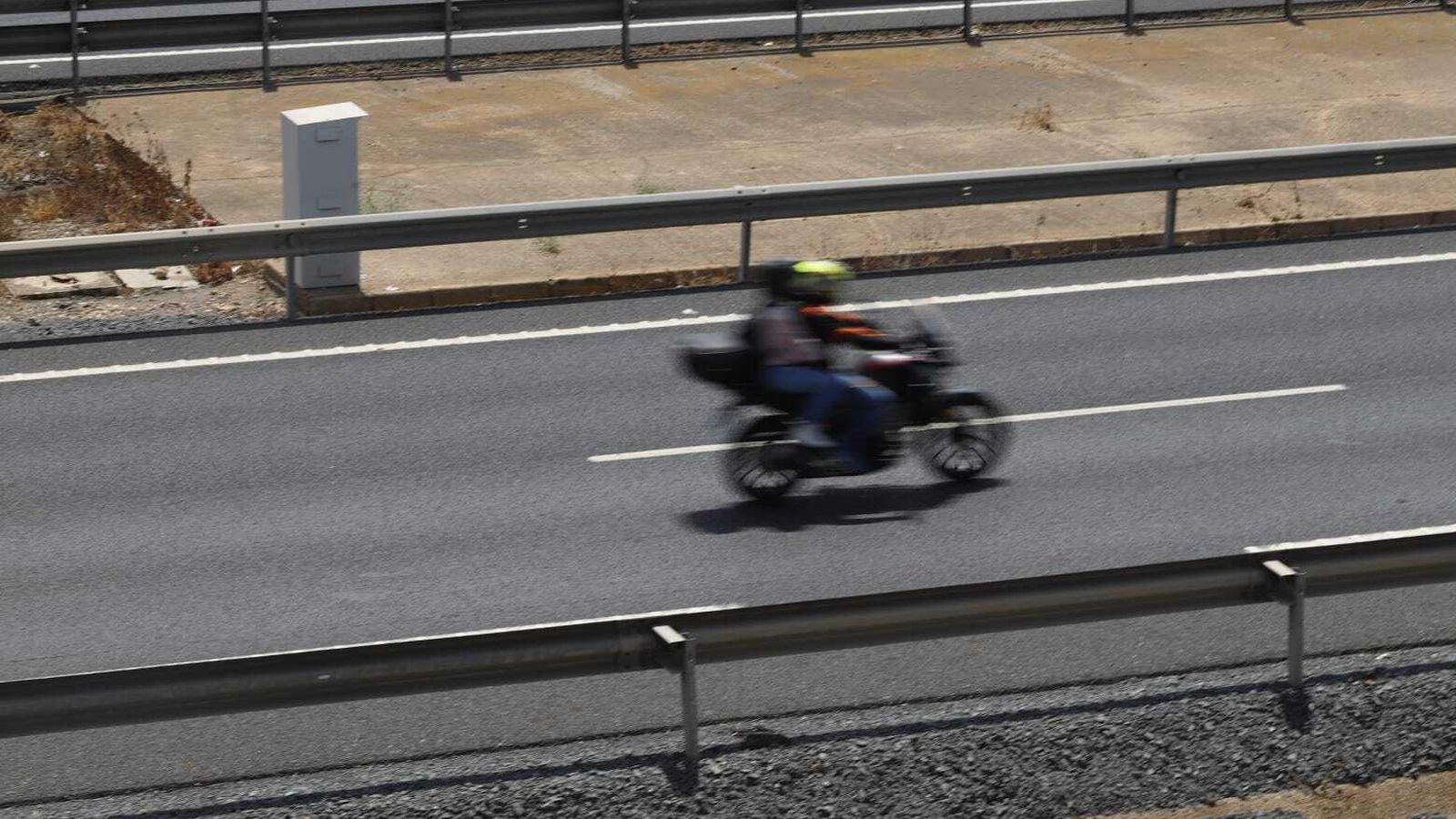 Una moto circulando junto al radar de la H-31.