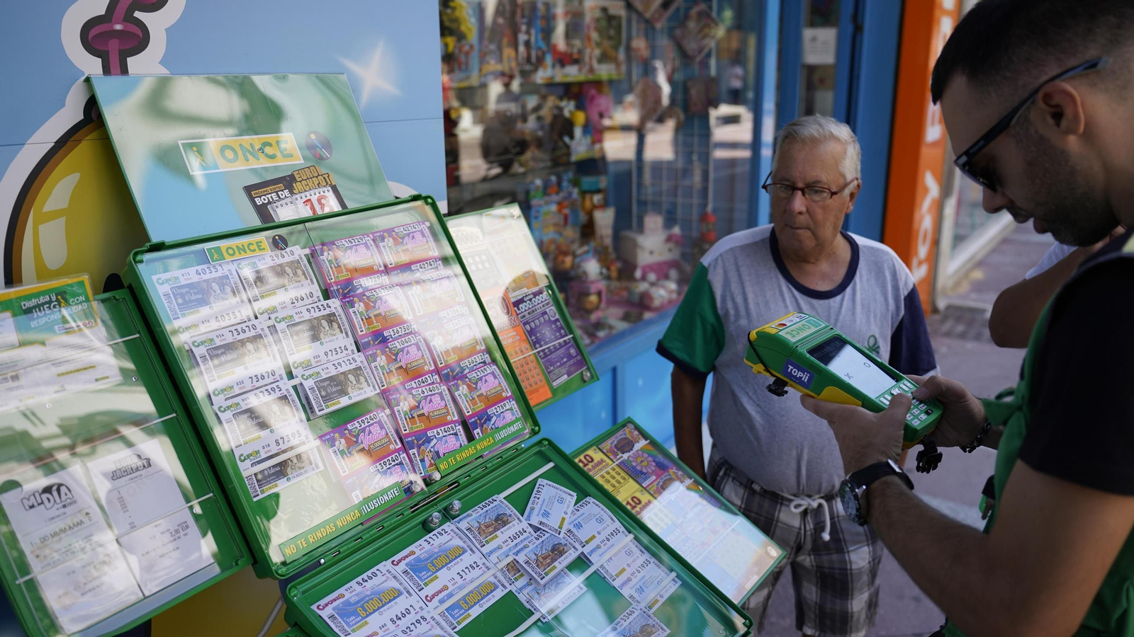 Un cuponero vende un número para el sorteo del jueves 14 de agosto en la calle Ancha.