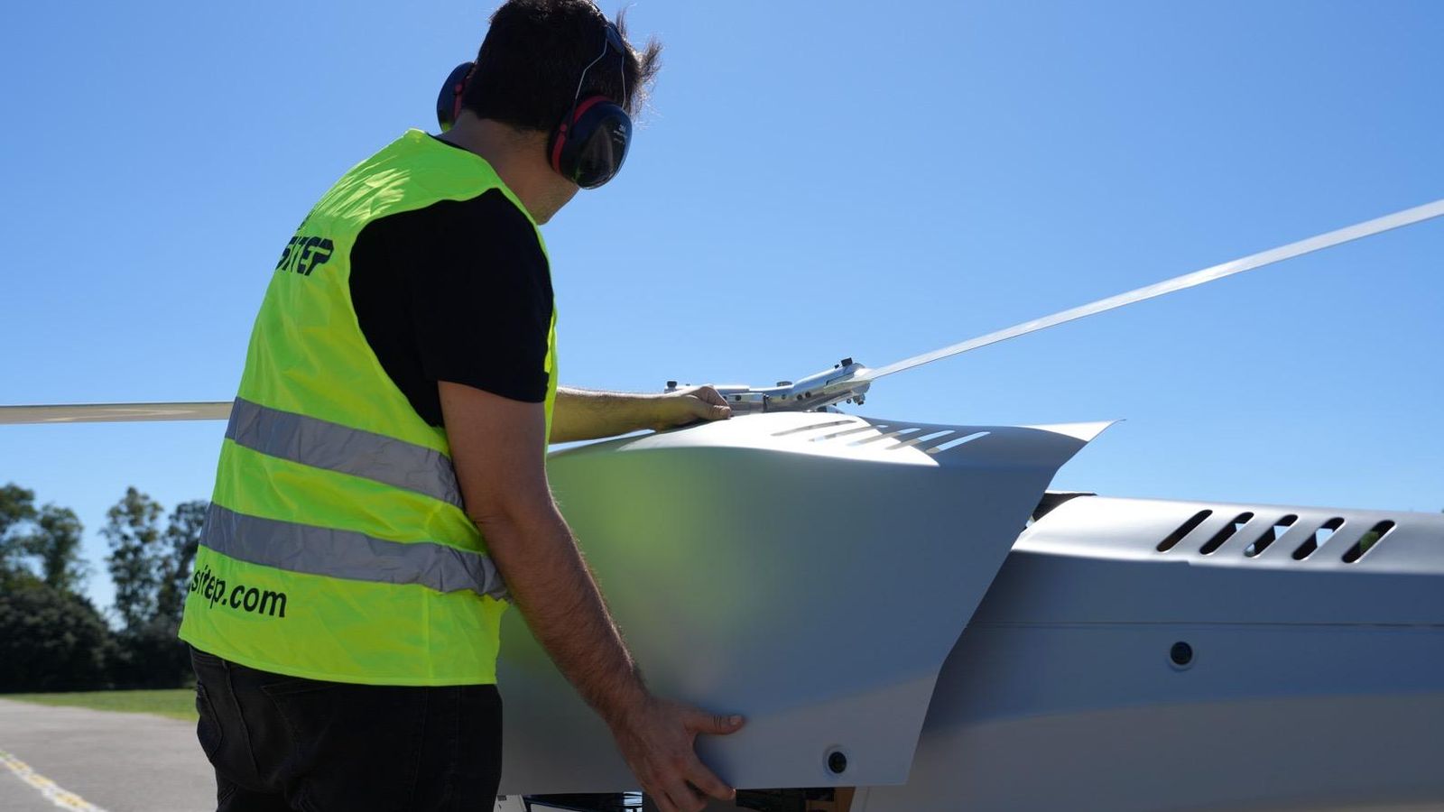 Un operador junto a un helicóptero.