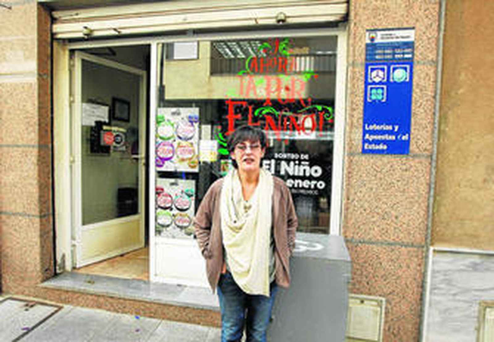 La encargada de llevar la suerte a Roquetas de Mar este 6 de enero fue Ángeles Martín, quien posa en la puerta de su comercio.