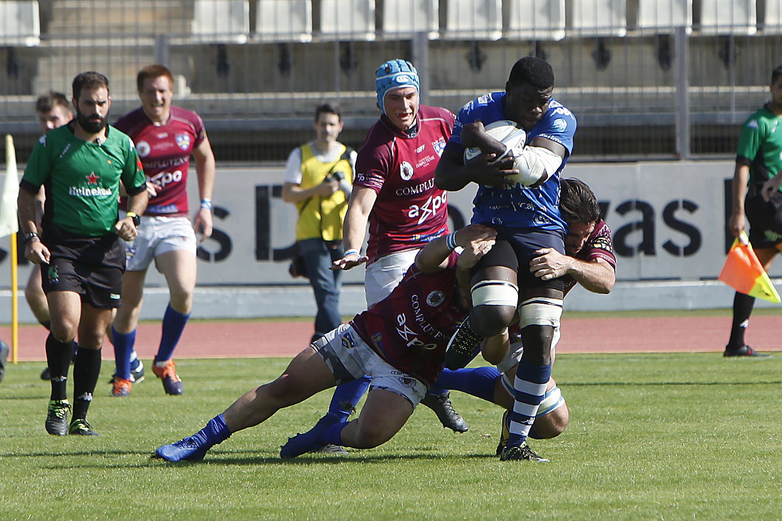 El jugador del Ciencias Enmanuel Bobo avanza ante el intento de dos rivales de placarlo.