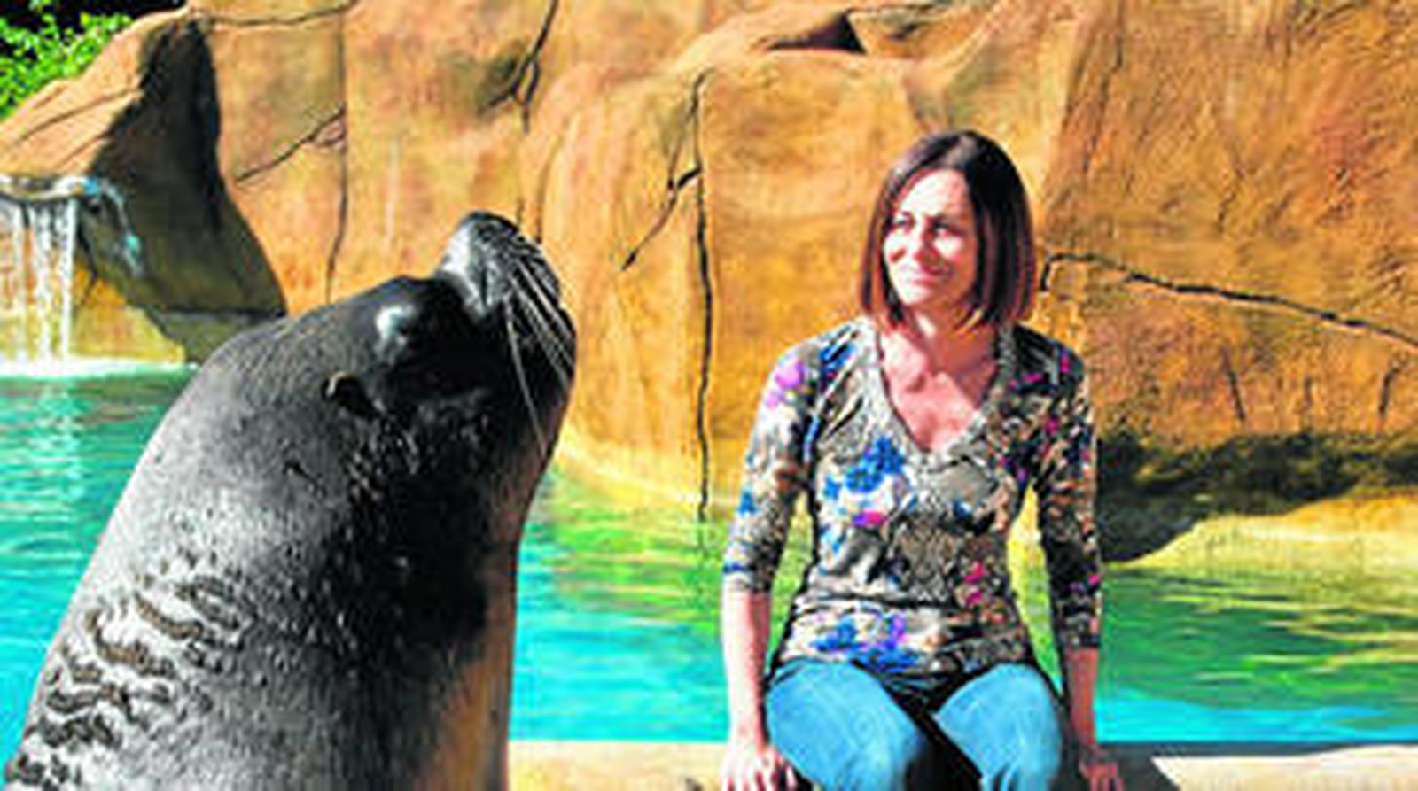 La gerente del Selwo Costa del Sol mira divertida a un león marino.